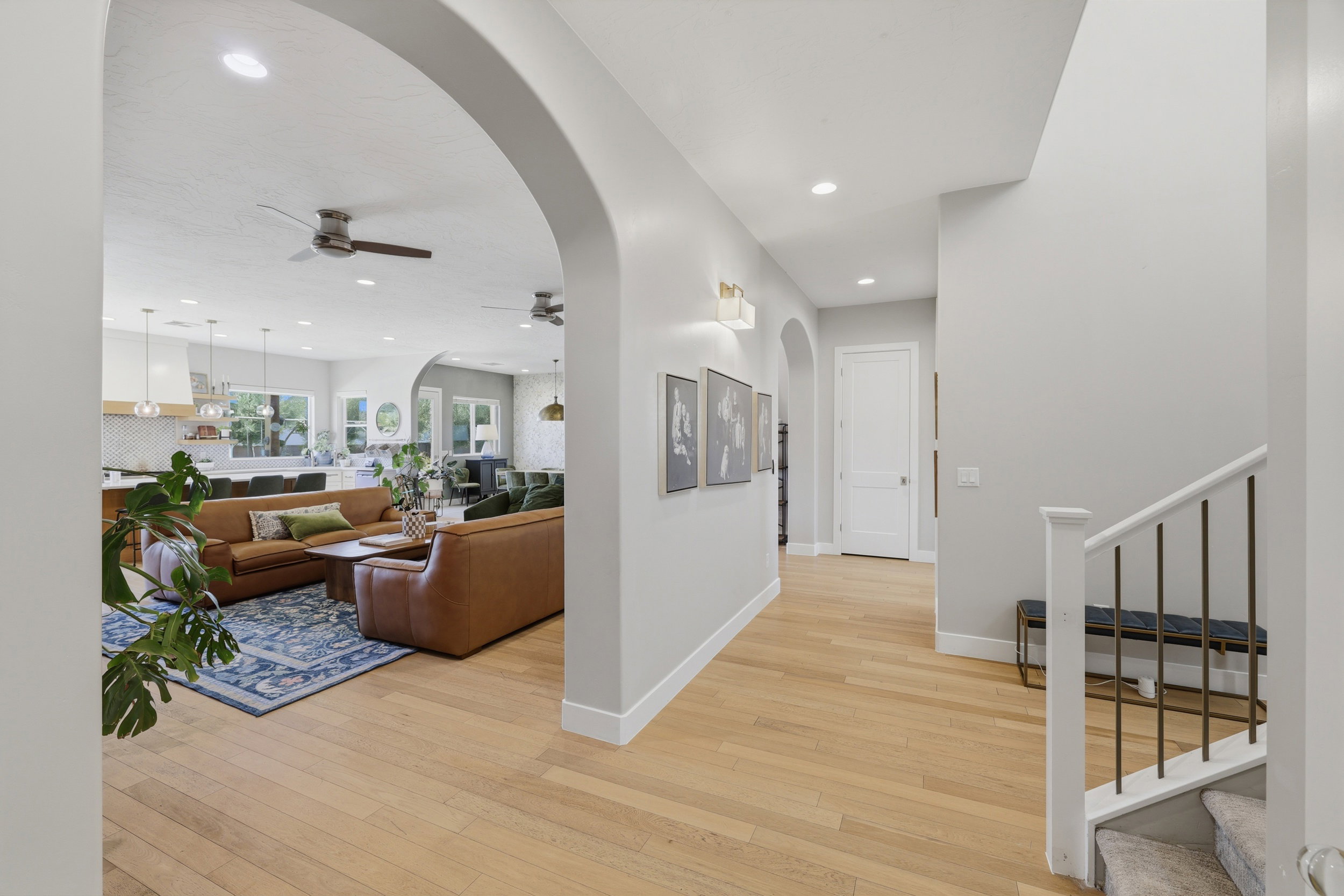 Open-concept living space featuring light wood-finish flooring, recessed lighting, and arched doorways