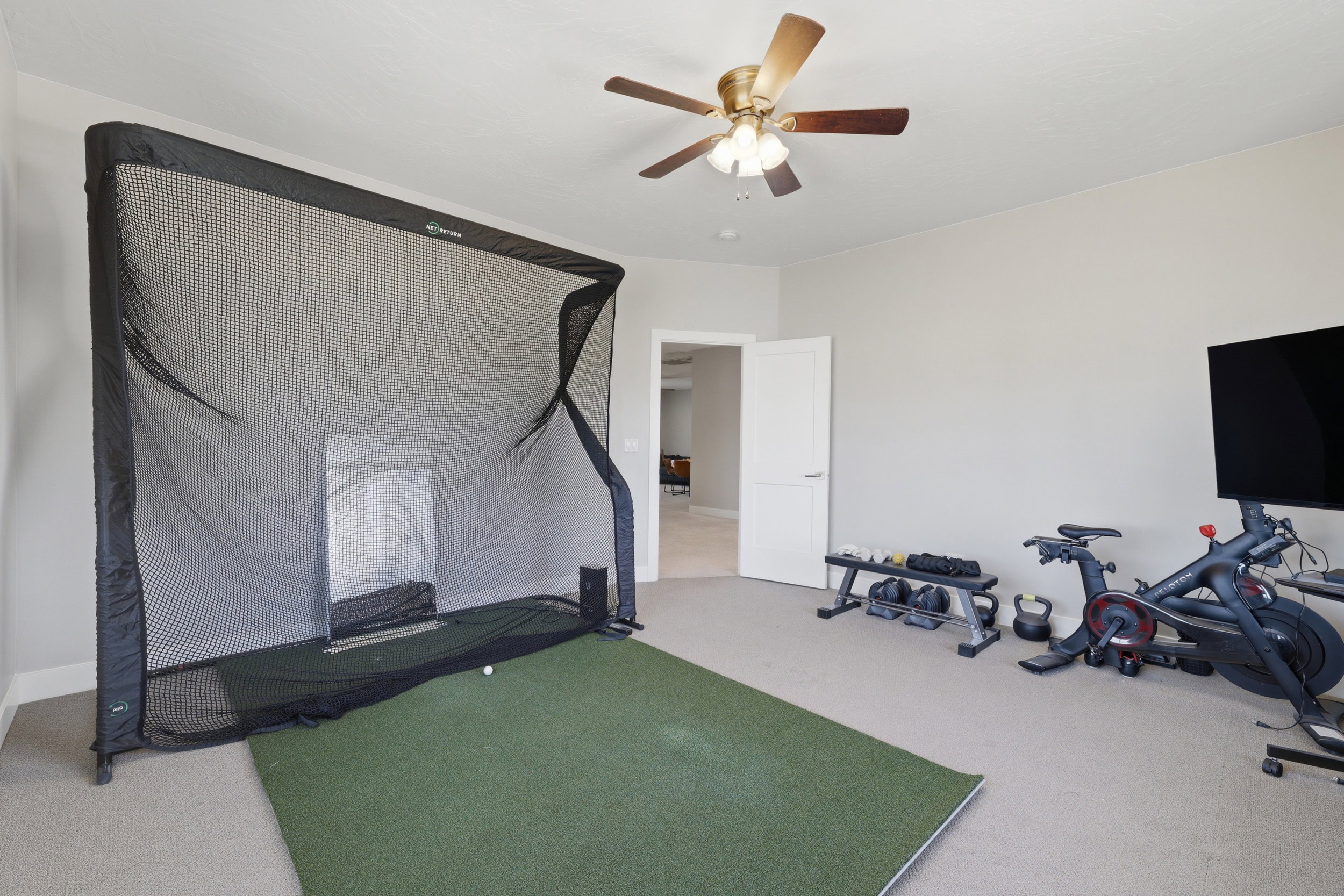 Versatile room featuring carpeting, a neutral wall color, and a ceiling fan with integrated lighting