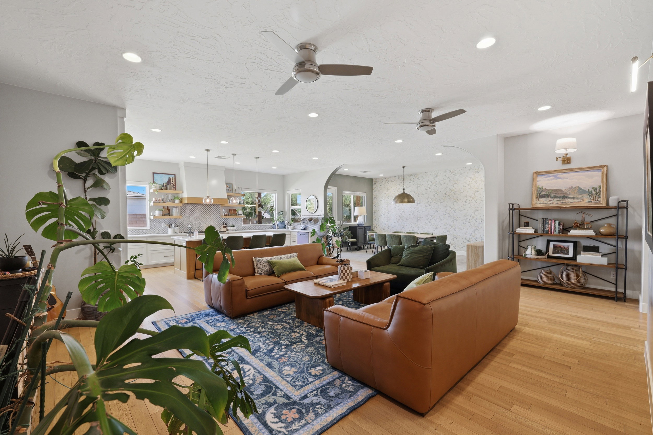 Open-concept living space featuring light wood-finish flooring, recessed lighting, and multiple ceiling fans