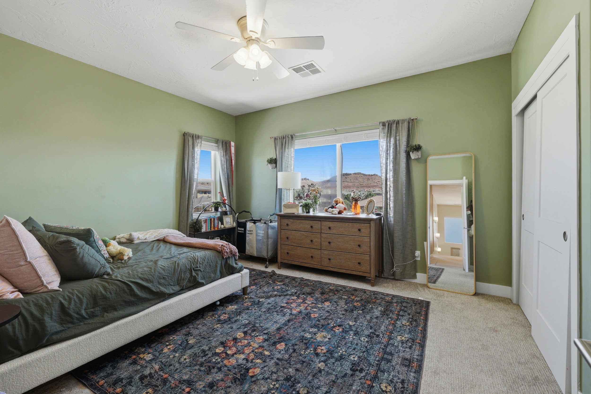 Spacious room featuring two large windows, offering abundant natural light and scenic mountain backdrops