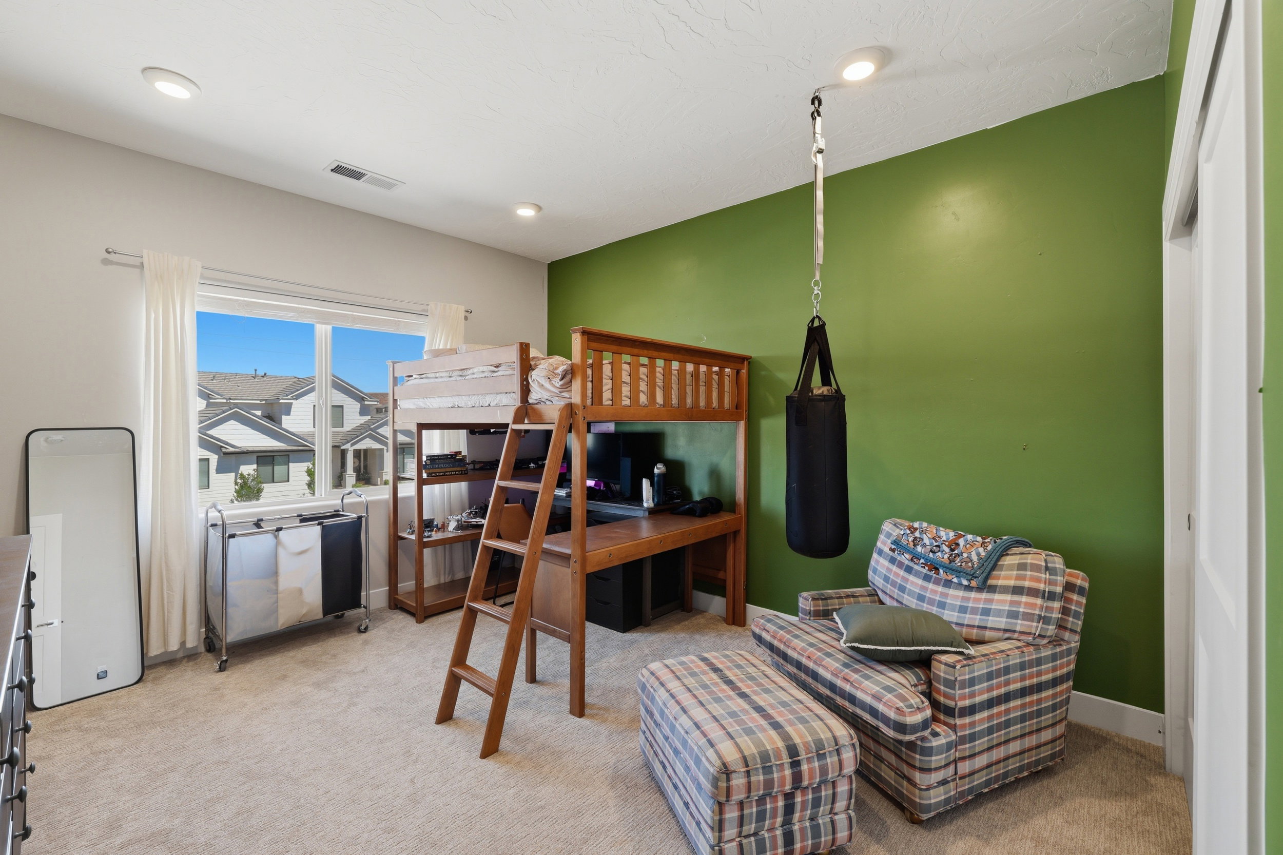 Carpeted room with a loft bed frame featuring an integrated desk