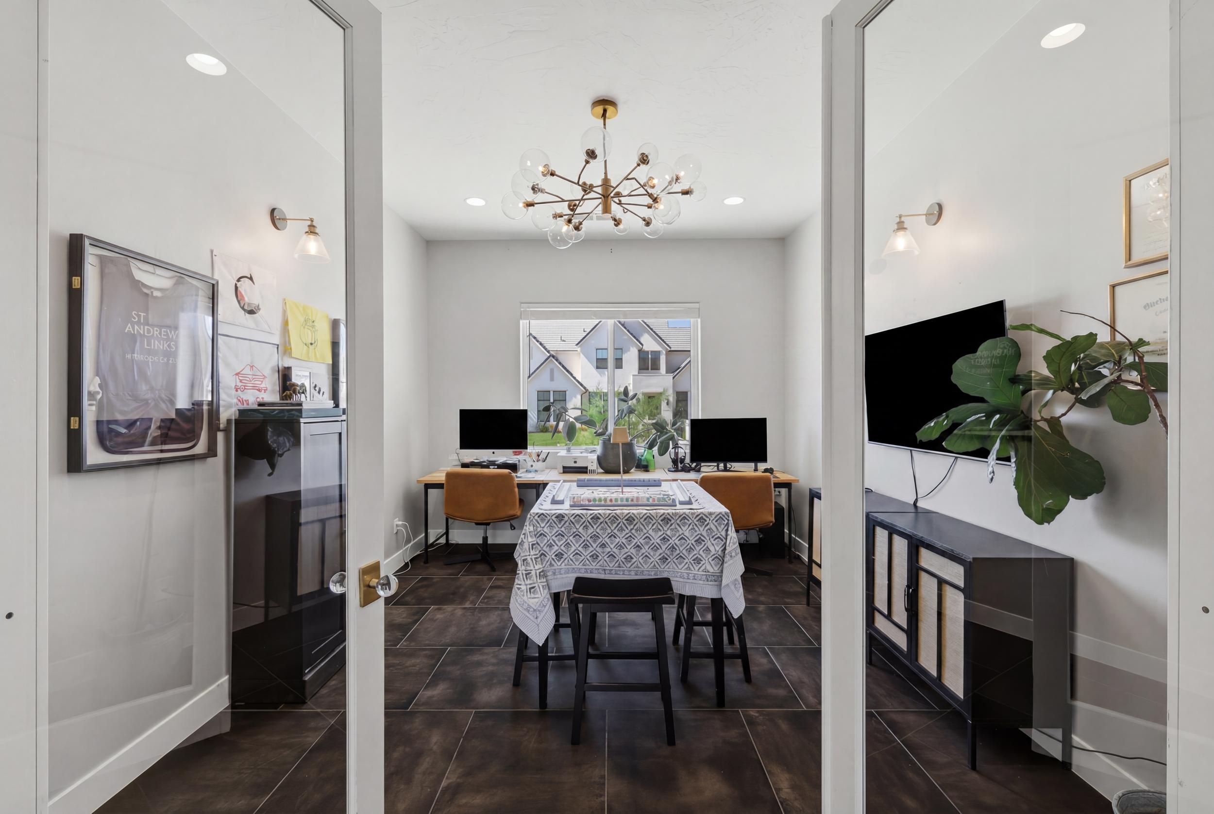 French doors with glass panels open to a versatile room featuring wood-finish flooring, a contemporary chandelier, and recessed lighting
