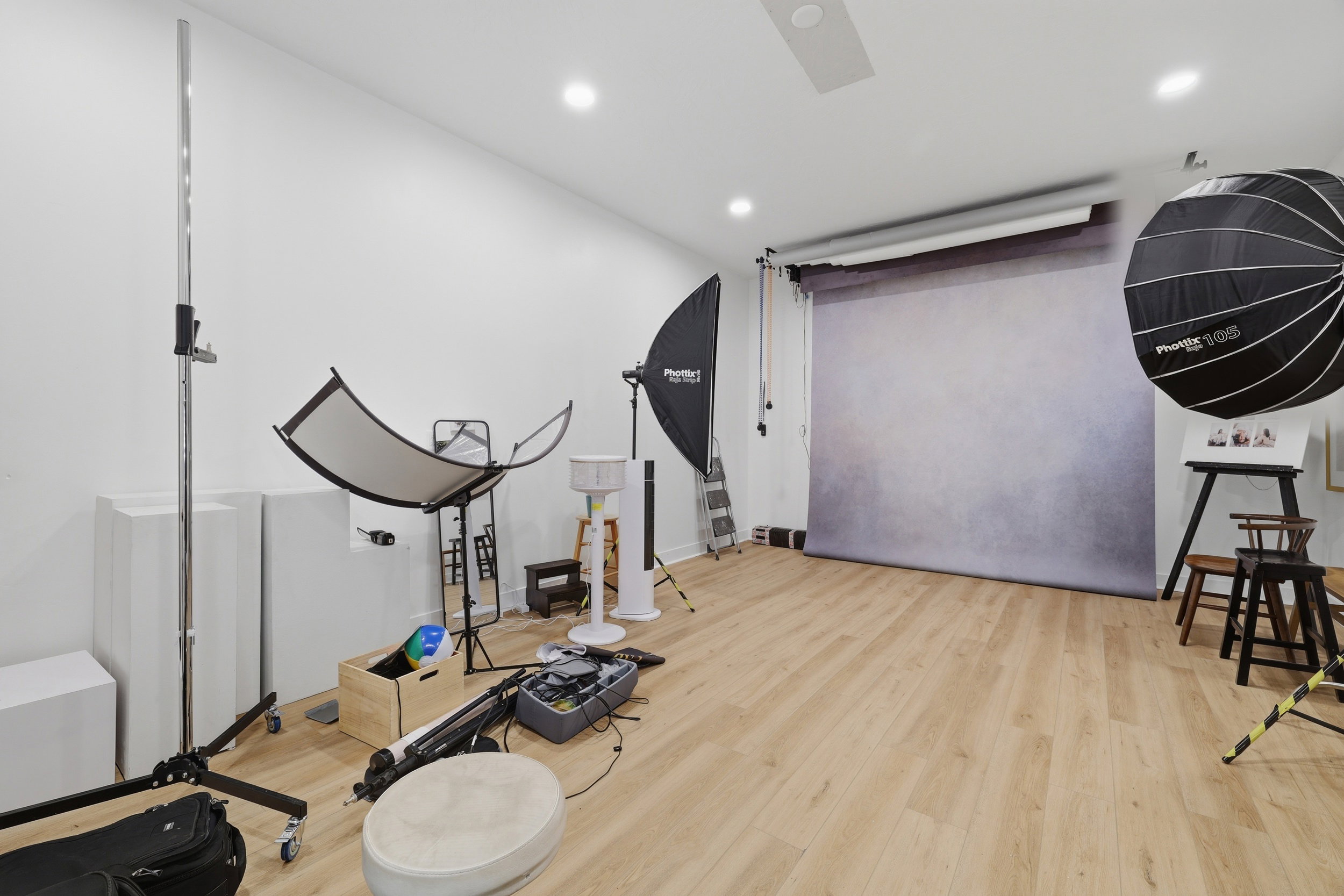 Spacious room featuring light wood-finish flooring, recessed lighting, and a white ceiling
