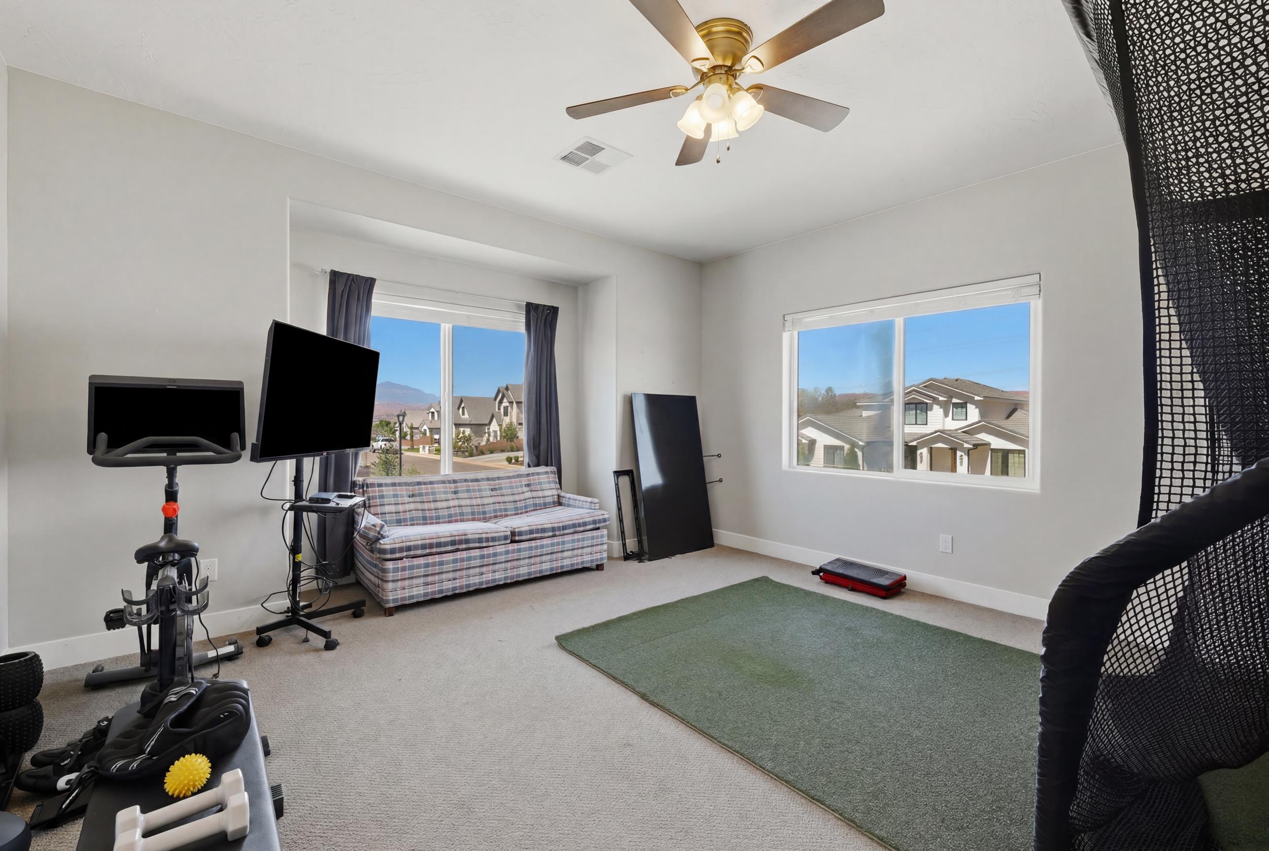 Spacious room featuring multiple windows, neutral wall tones, and carpet flooring