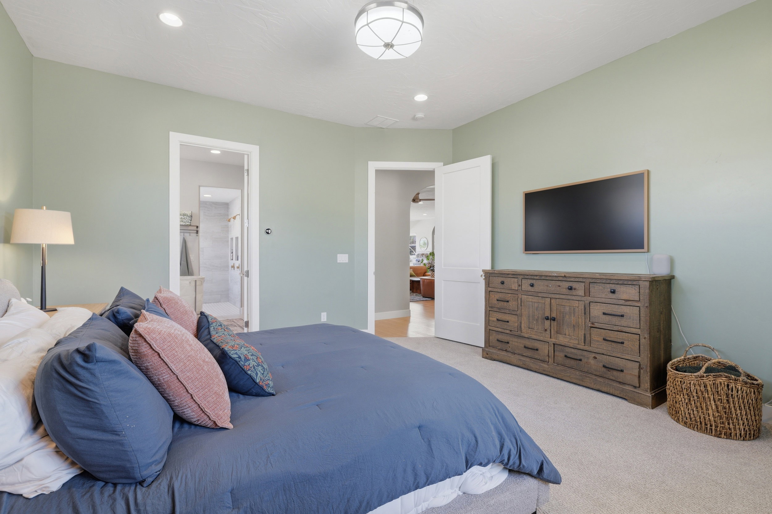 Bedroom featuring light green walls and light-toned carpet flooring