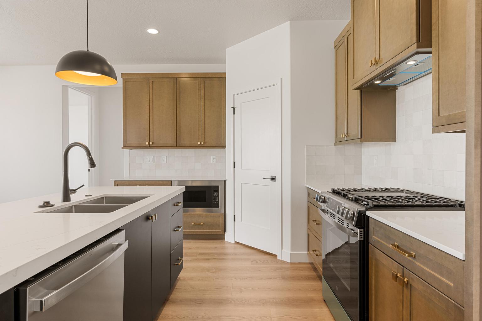Modern kitchen featuring a large island with a double sink and stainless steel dishwasher
