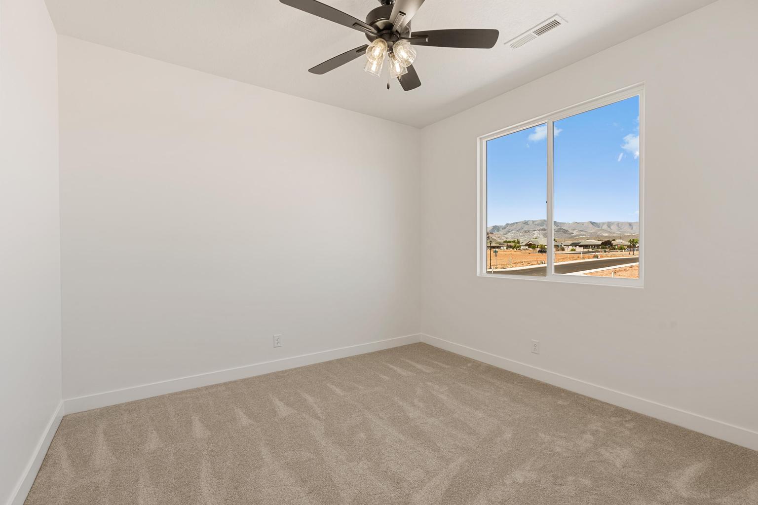 Carpeted room featuring a ceiling fan with integrated lighting, a large window, white walls, and white trim