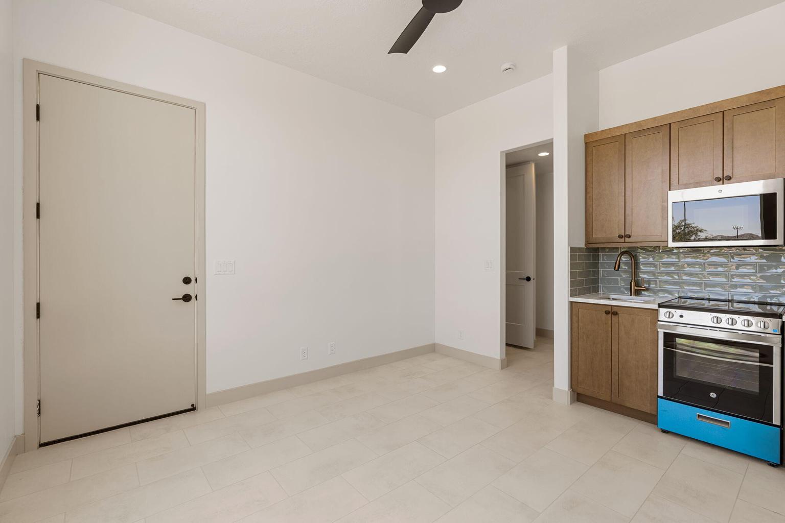 Compact kitchen area featuring wood-finish cabinetry, a stainless steel oven/range, and a matching microwave