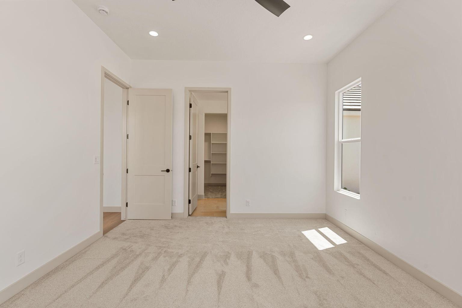 Carpeted room featuring white walls, recessed lighting, and a modern ceiling fan