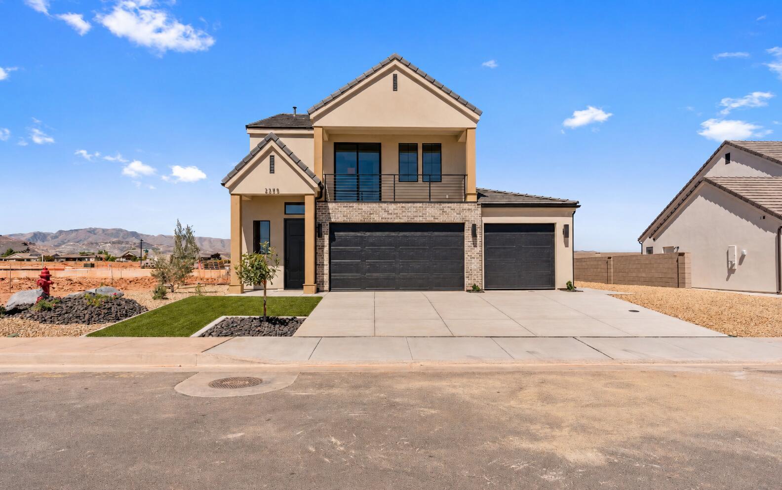 Contemporary residence featuring a stucco exterior with stone accents and a tiled roof