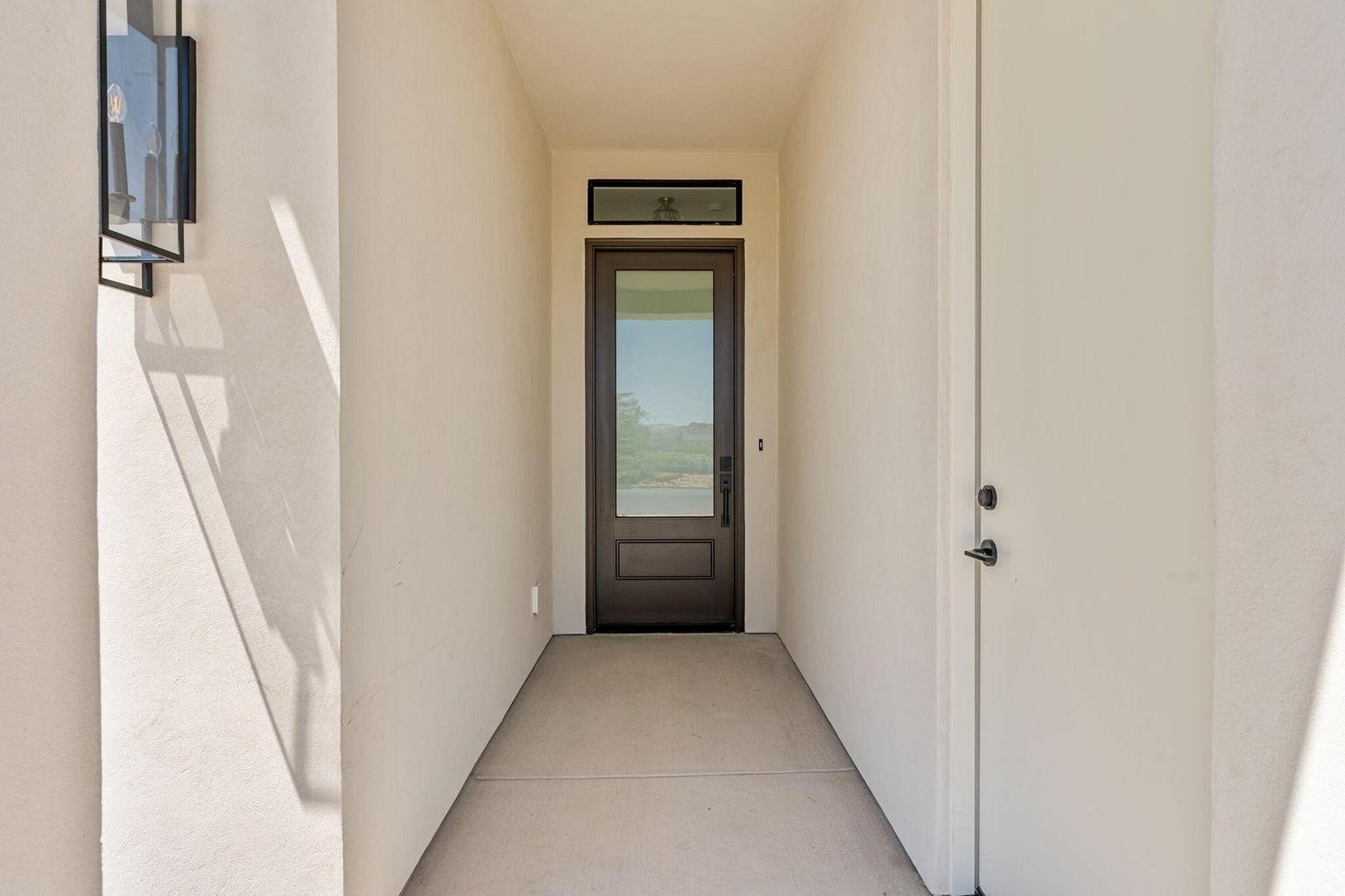 Contemporary entryway featuring a dark brown full-lite door with transom window