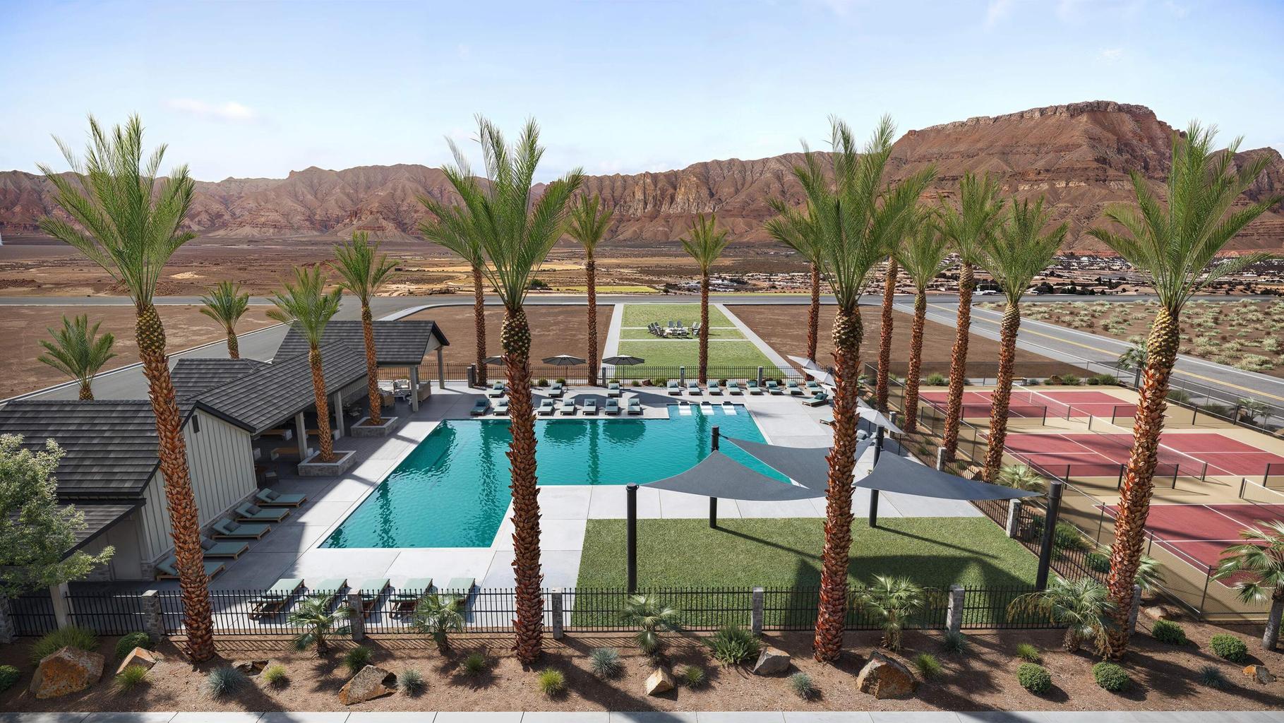 Expansive outdoor amenity area featuring a large swimming pool, multiple lounge chairs, shade structures, and surrounding palm trees