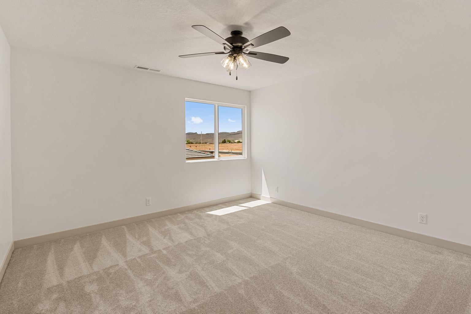 Neutral-toned room featuring a large window, light gray carpeting, and white baseboards