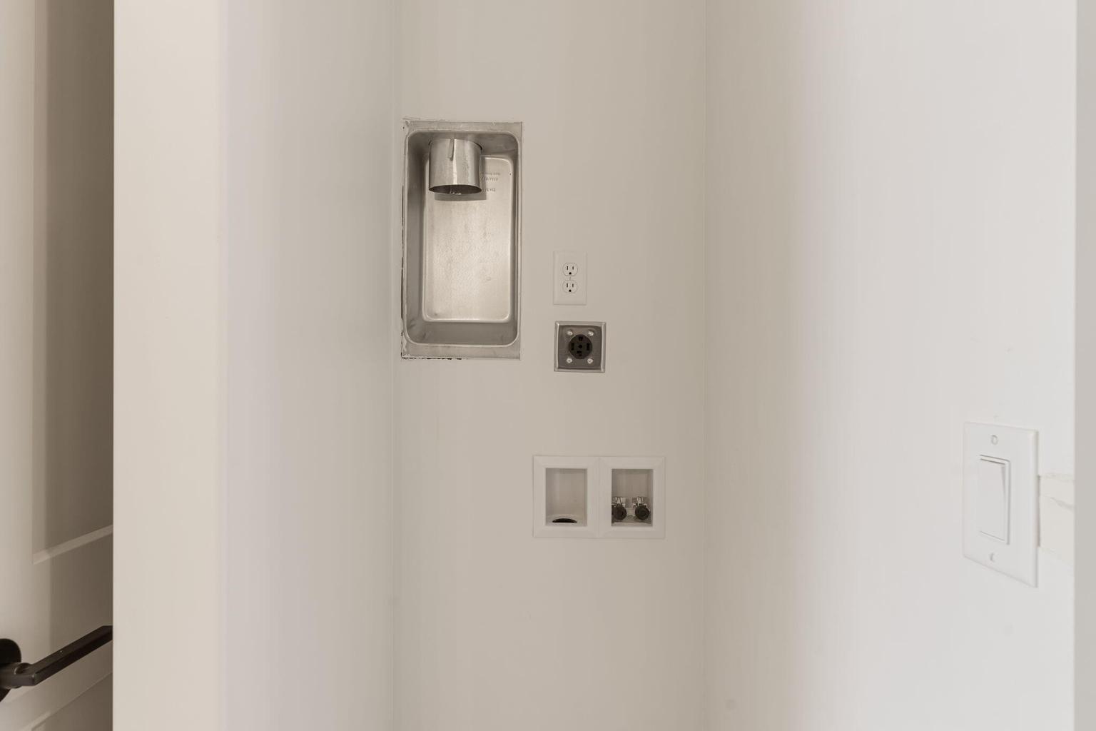 Dedicated utility area featuring a recessed dryer vent box, 240V outlet, and hot and cold water hookups