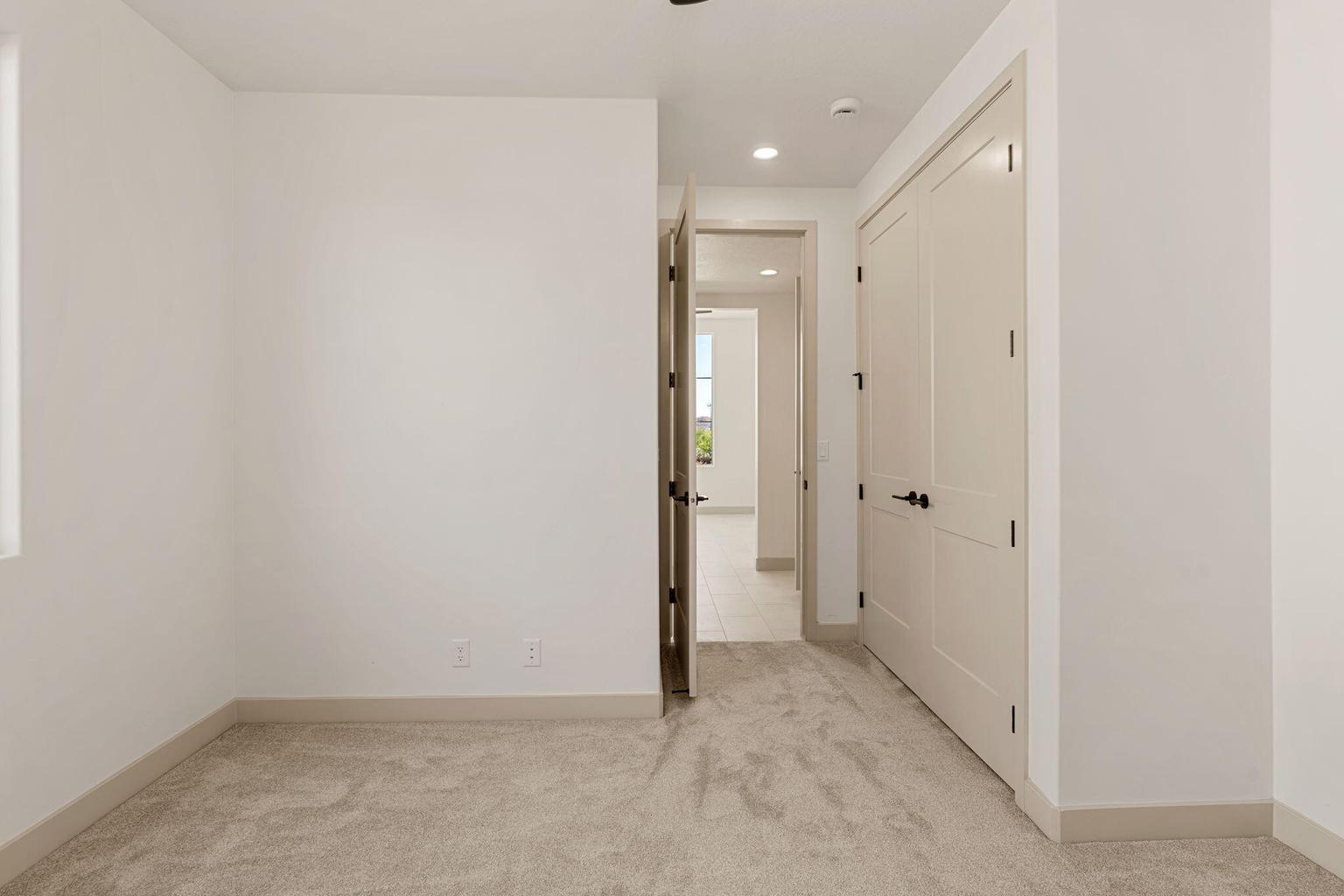 Light-colored carpeted flooring extends through this interior space, complemented by a pale neutral wall color and corresponding baseboards