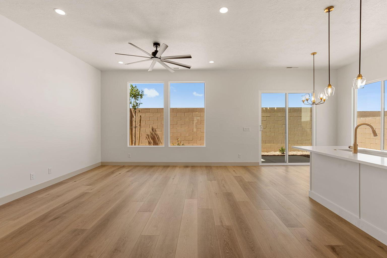 Open-concept living area featuring wood-finish flooring, recessed lighting, and a modern ceiling fan