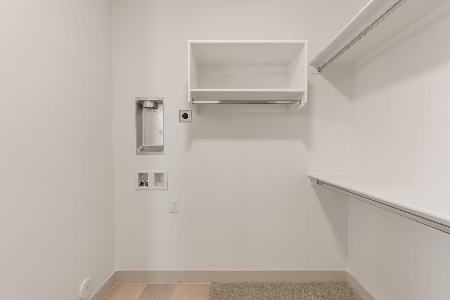 Dedicated laundry area featuring a wall-mounted utility box, appliance hookups, and a wall outlet