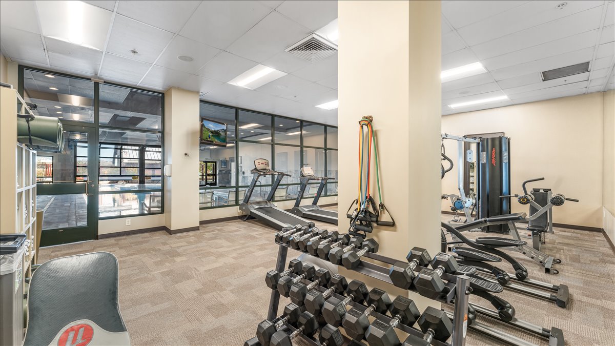 Fitness center featuring glass wall partitions and durable carpet tile flooring