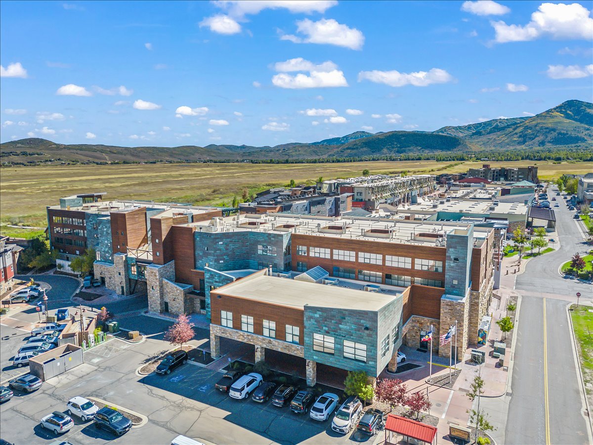 Mixed-use development featuring stone and wood-look facades with copper accents