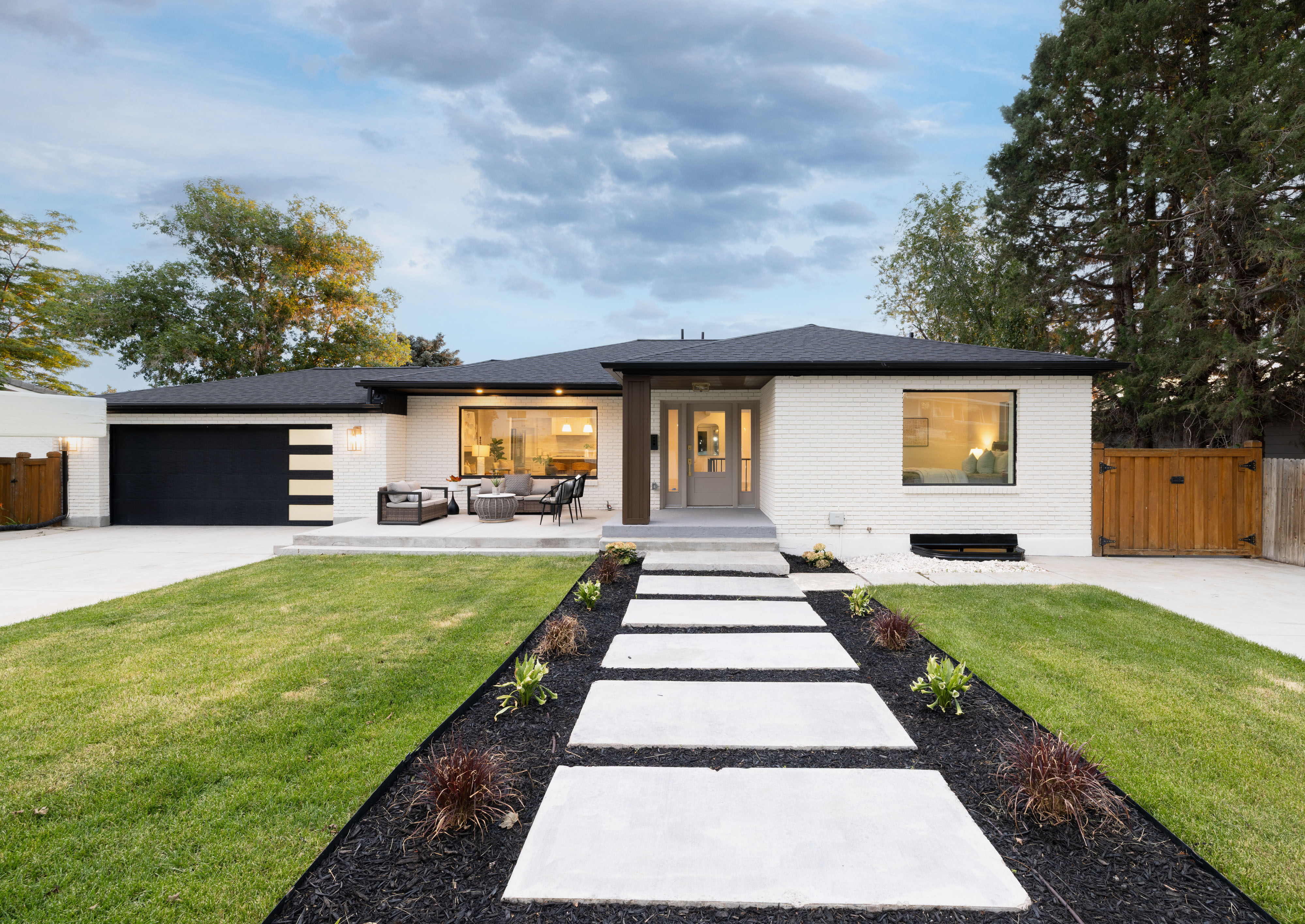 Contemporary single-story residence featuring a white brick exterior and a dark roof
