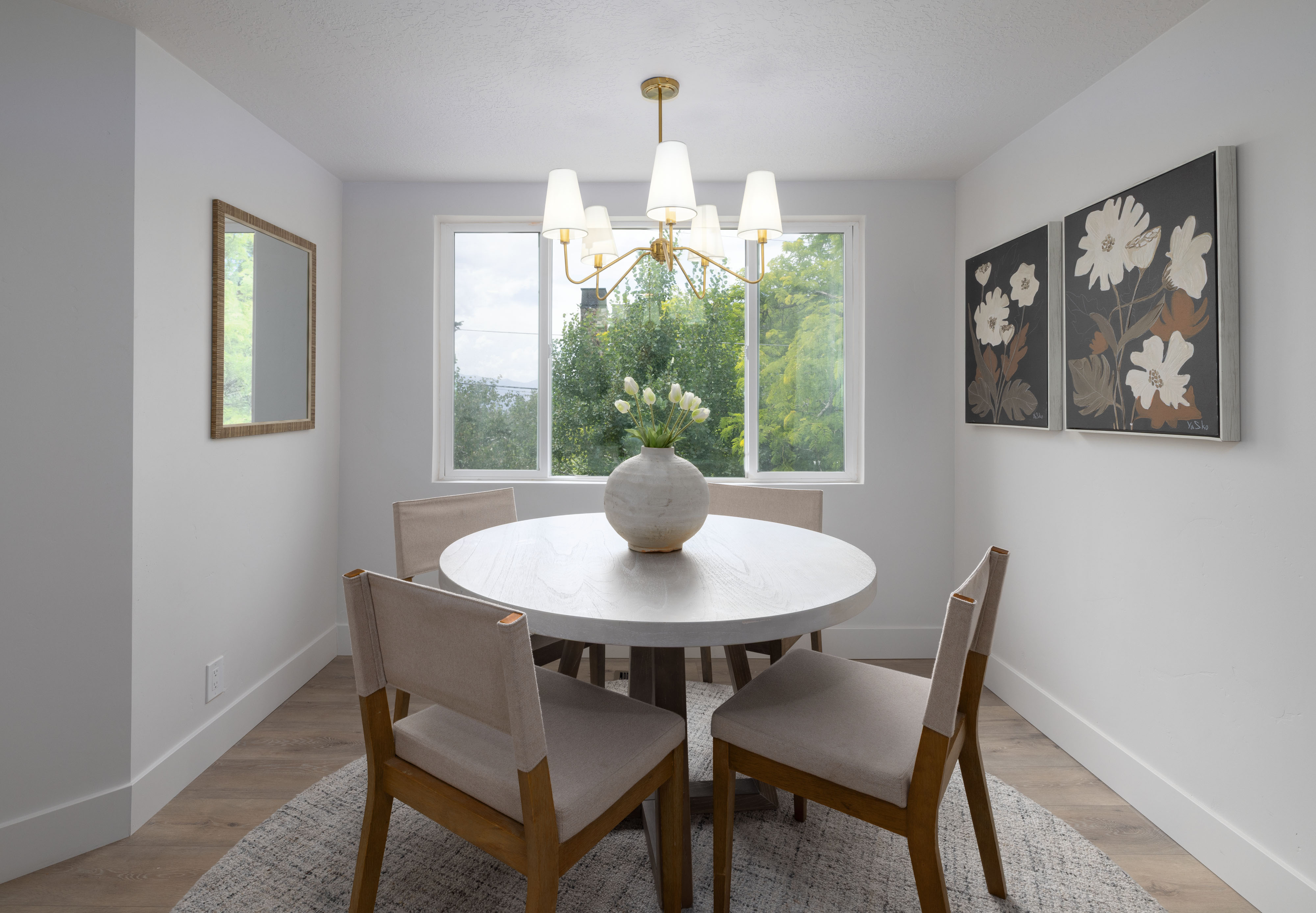 Dedicated dining area featuring wood-finish flooring, white baseboards, and a contemporary chandelier