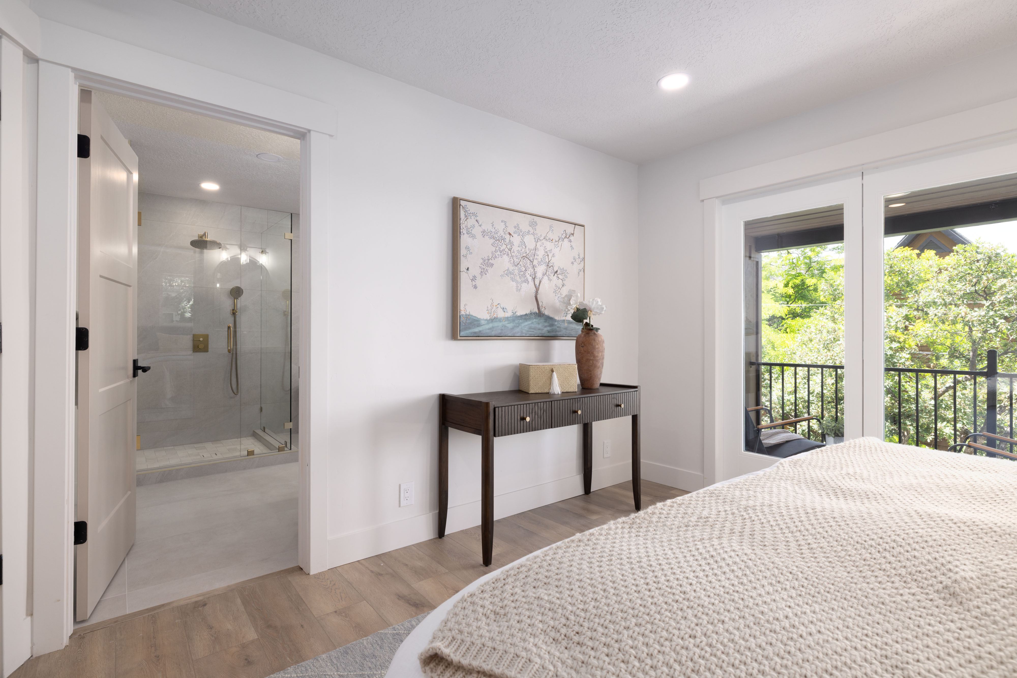 Spacious room featuring wood-finish flooring, recessed lighting, and a private balcony with black metal railings