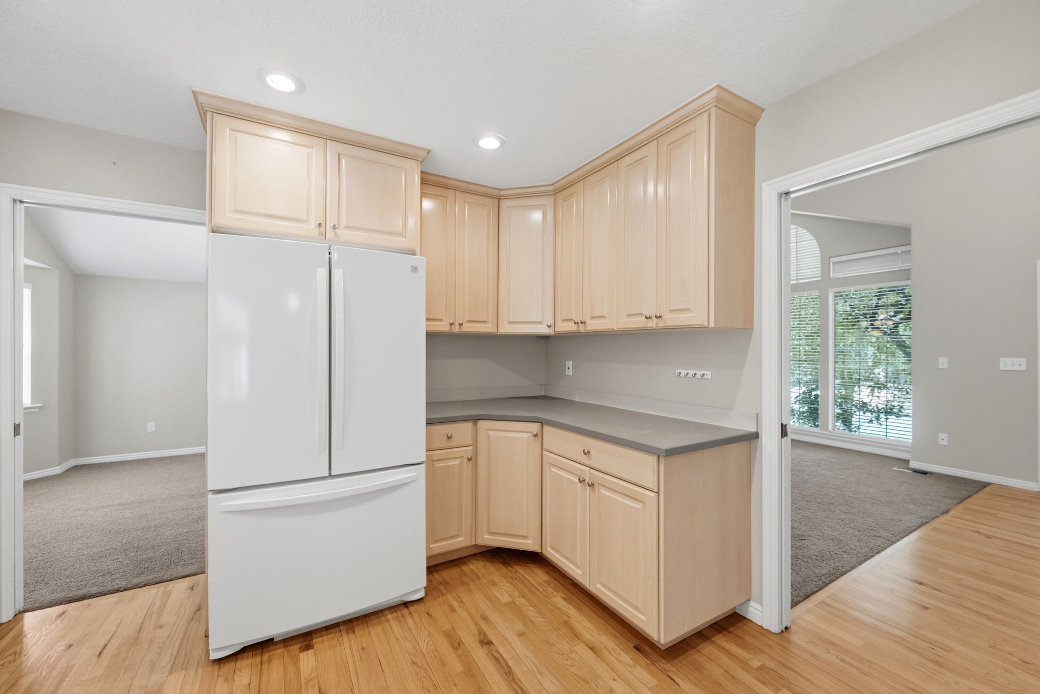 Kitchen featuring blonde wood cabinetry, recessed lighting, and wood-finish flooring