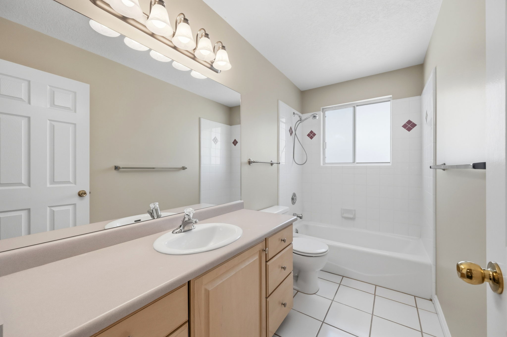 Full bathroom featuring a single vanity with an integrated sink, a large mirror, and ample under-sink storage