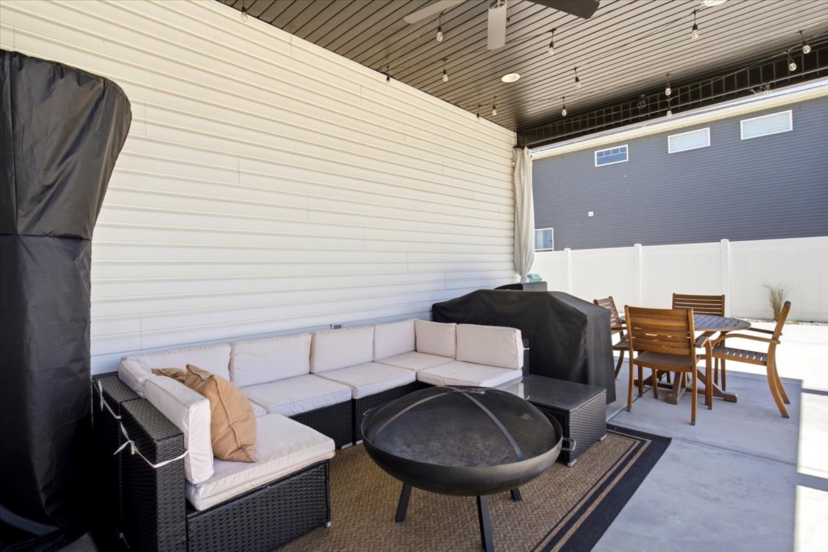 Expansive covered patio featuring a concrete slab, white vinyl siding, and a contrasting dark soffit
