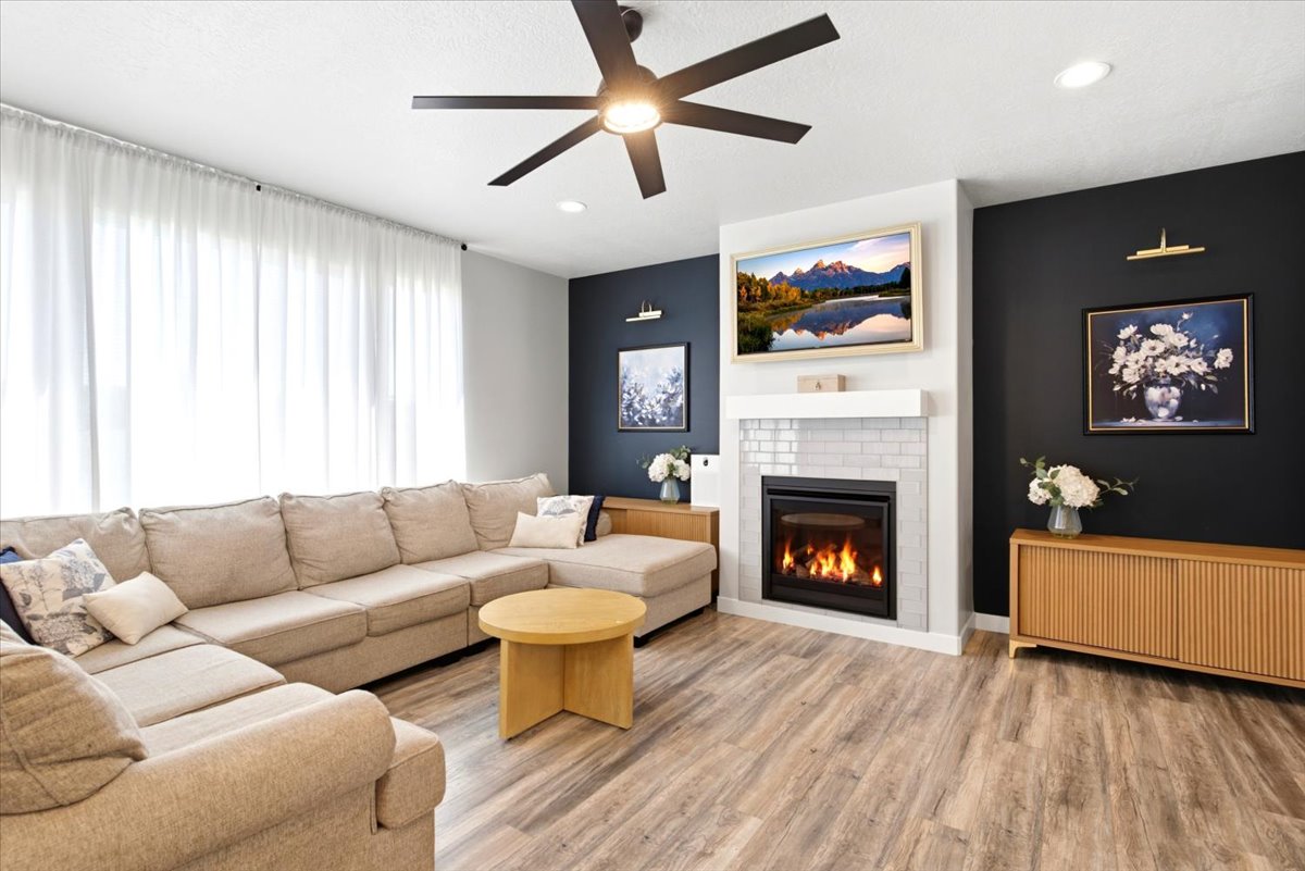 Living area featuring wood-finish flooring, a contemporary ceiling fan, and recessed lighting