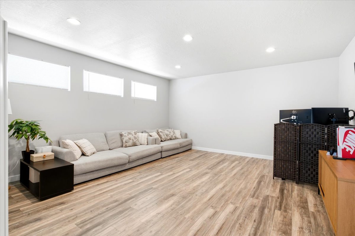 Spacious room featuring wood-finish flooring, recessed lighting, and light gray wall tones