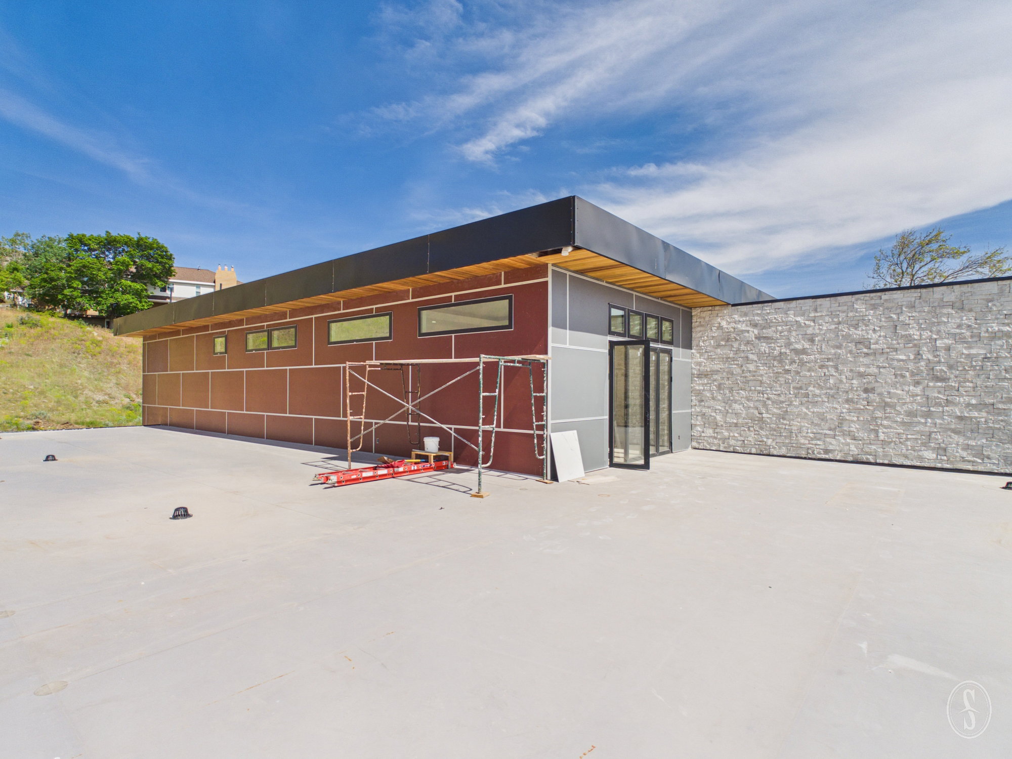 Modern architectural design featuring varied exterior paneling and a stone accent wall