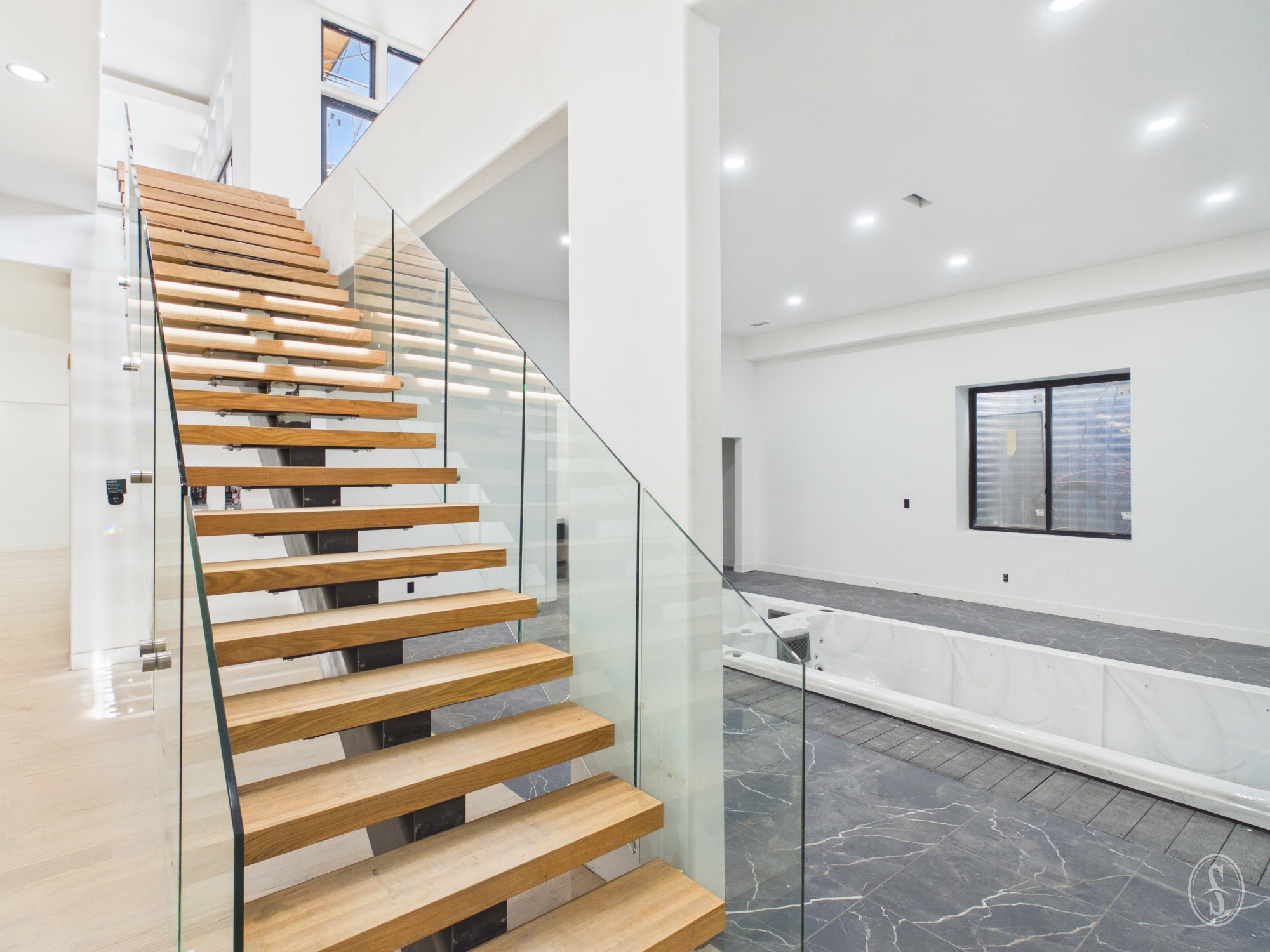 Floating wood-finish staircase with glass panel railing