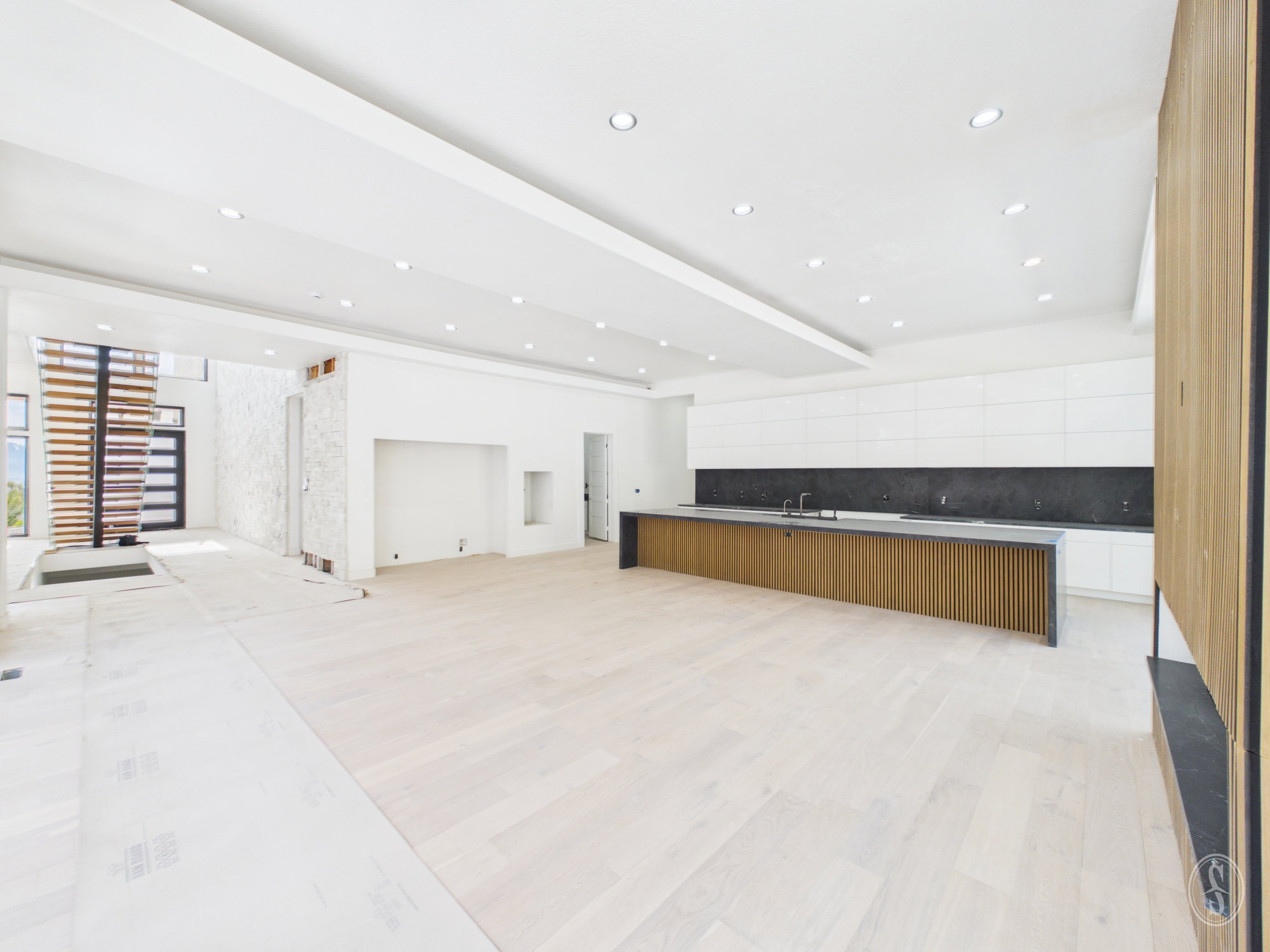 Open-concept interior featuring light wood-finish flooring and recessed lighting