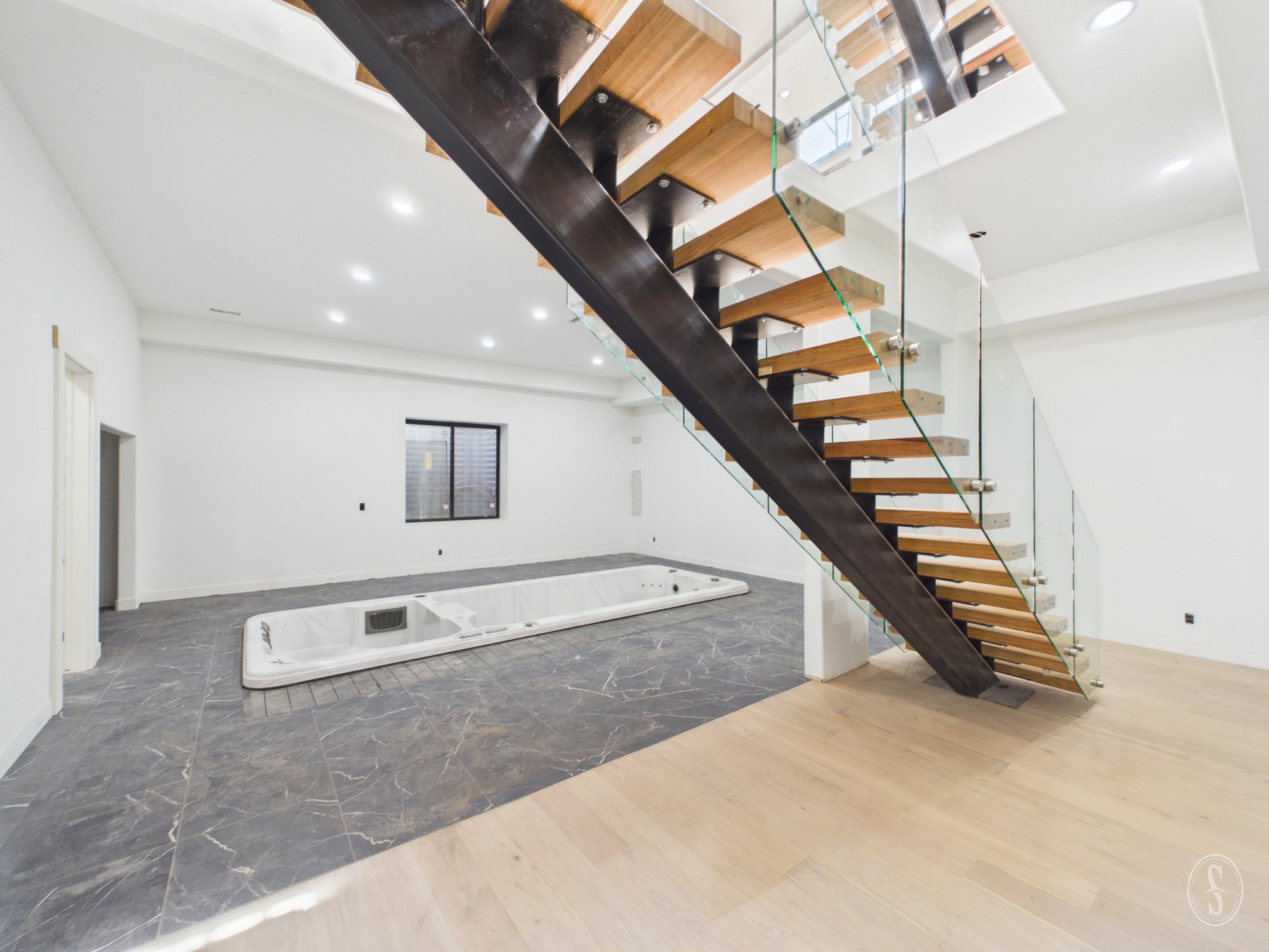 Contemporary floating staircase with glass railings and wood treads