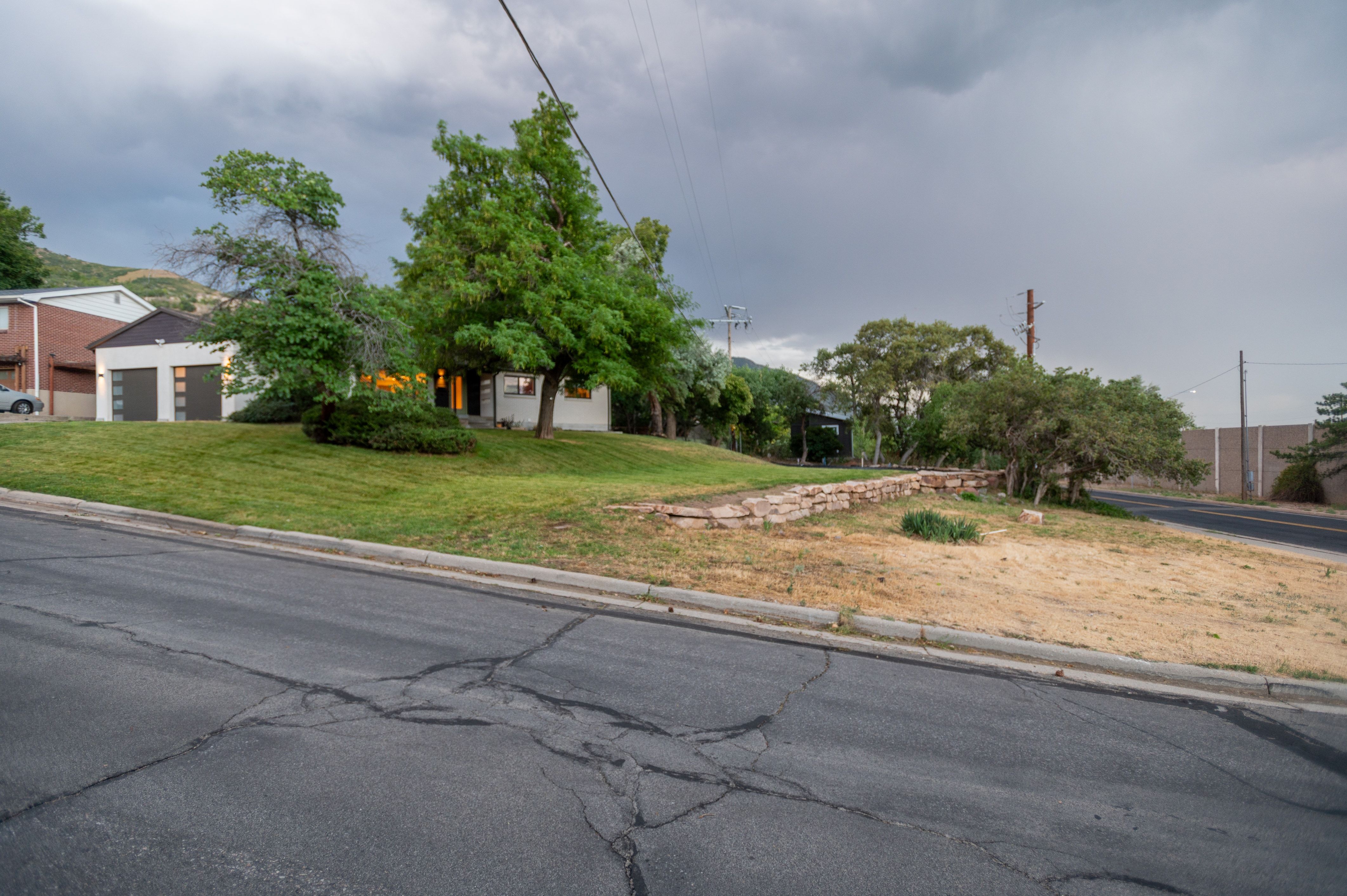 Property featuring a white-painted exterior, a modern garage with two doors, and a well-maintained grassy lawn