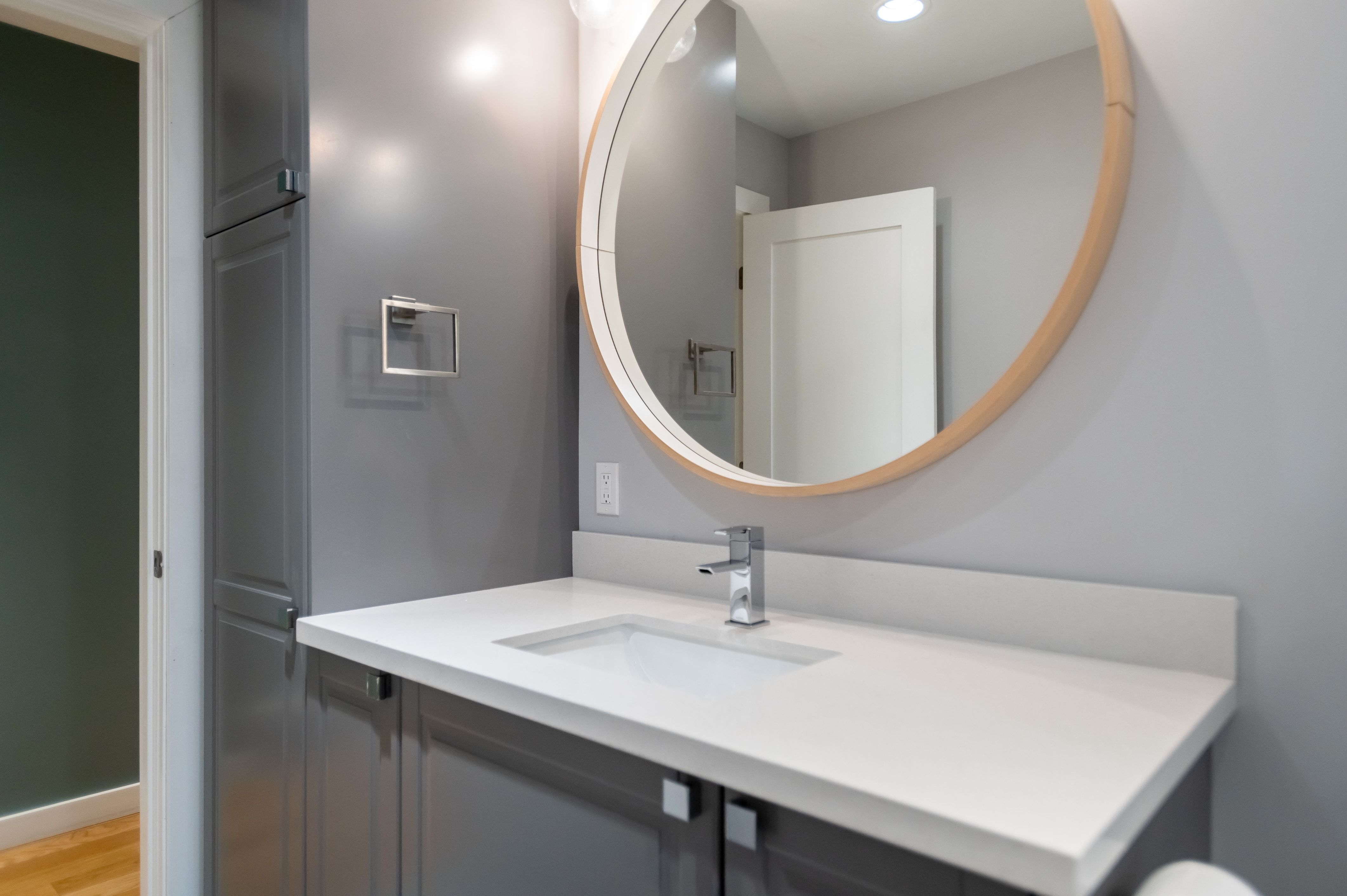 Bathroom vanity featuring a white rectangular undermount sink, a chrome single-handle faucet, and a white countertop