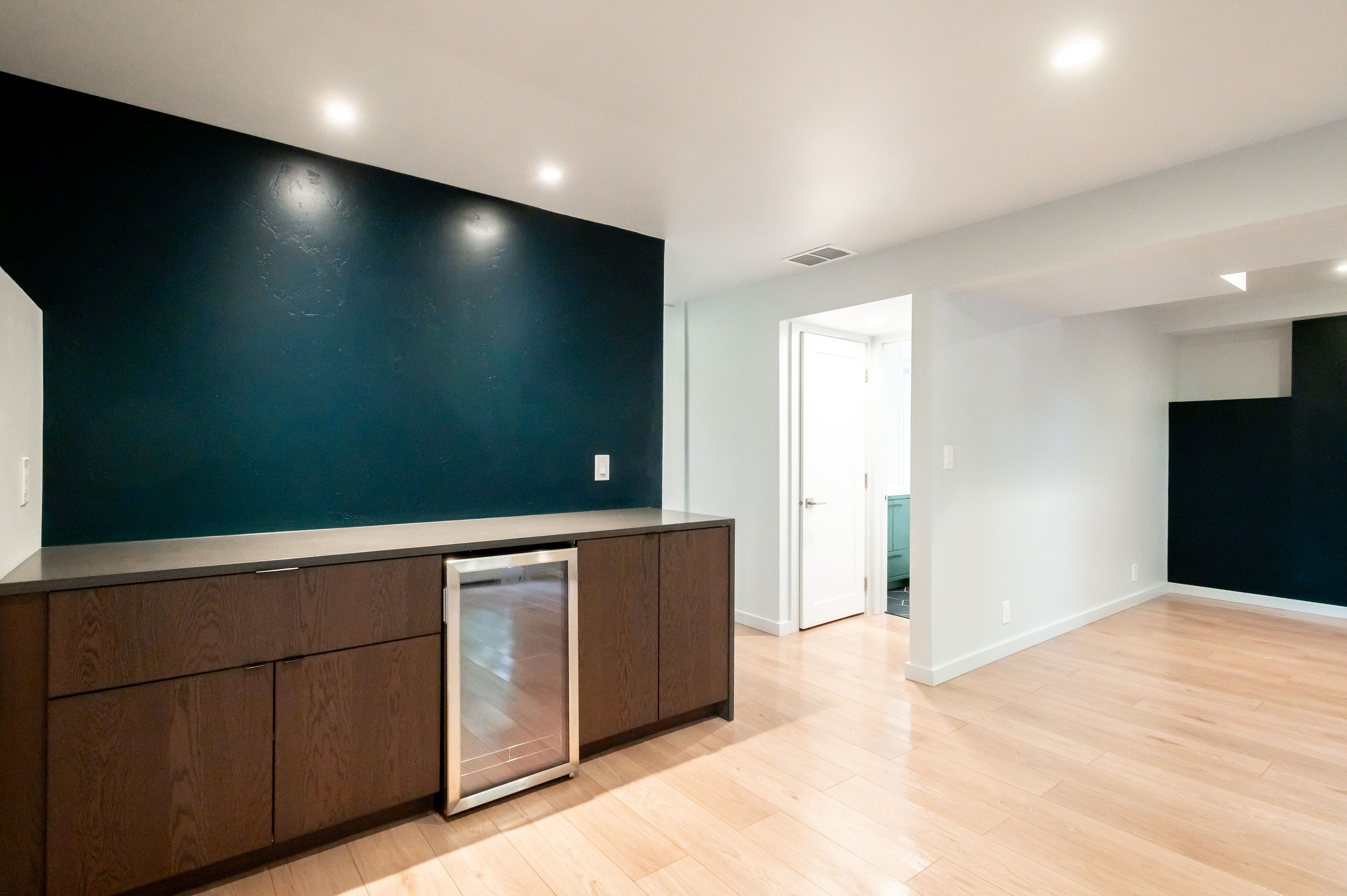 Built-in cabinetry with a dark wood finish and integrated beverage cooler, complemented by a sleek countertop