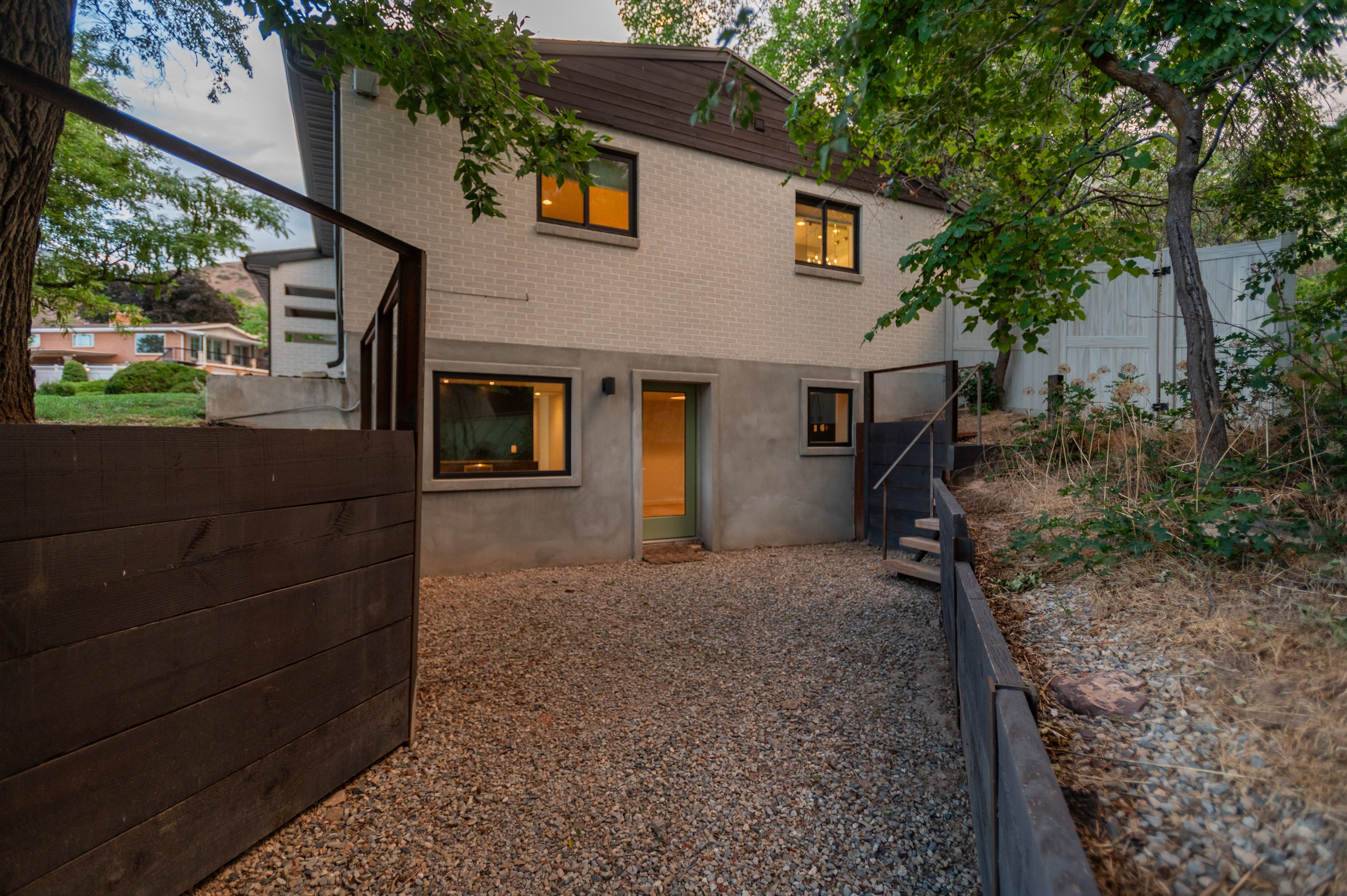 Lower-level exterior featuring white brick siding and a brown roofline