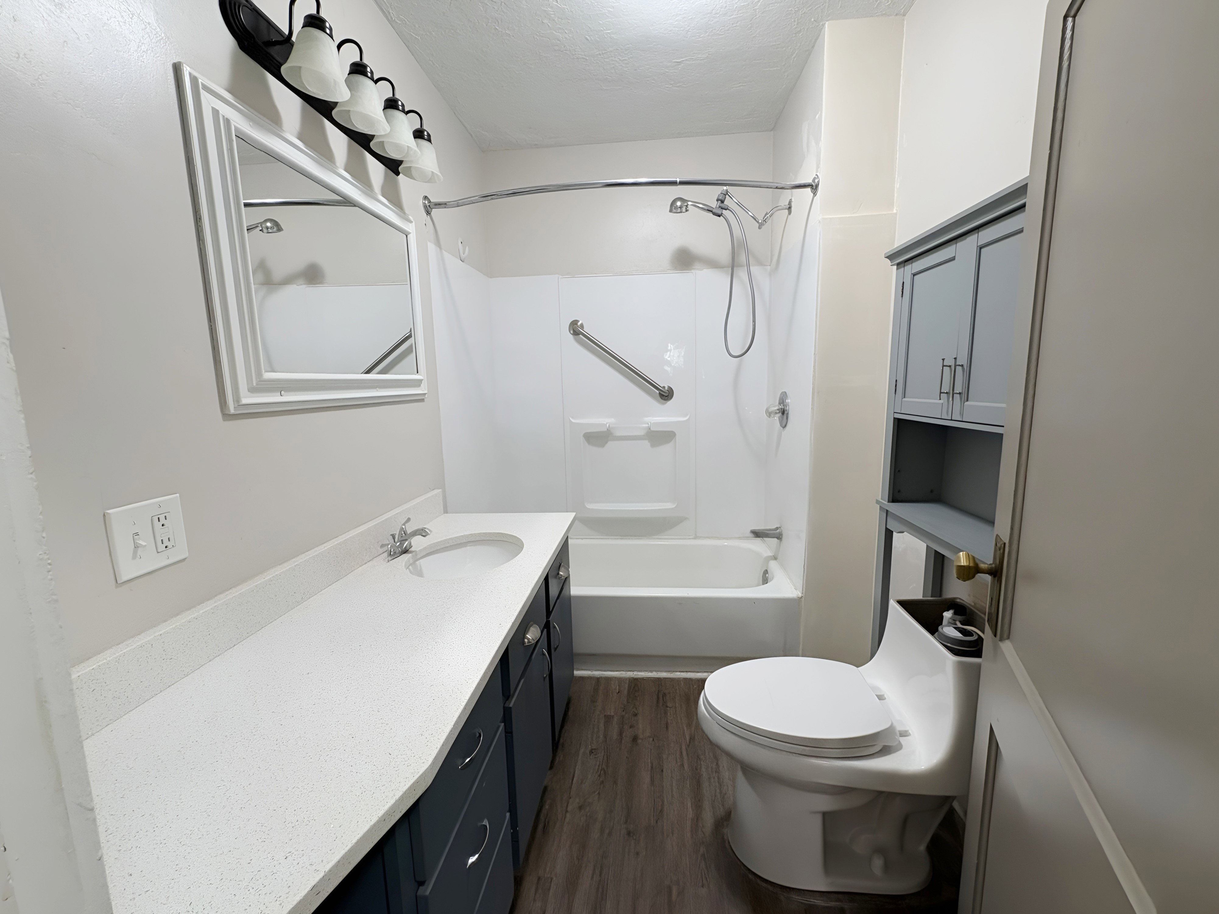 Bathroom featuring a spacious vanity with a white speckled countertop, integrated sink, and dark wood-finish cabinetry