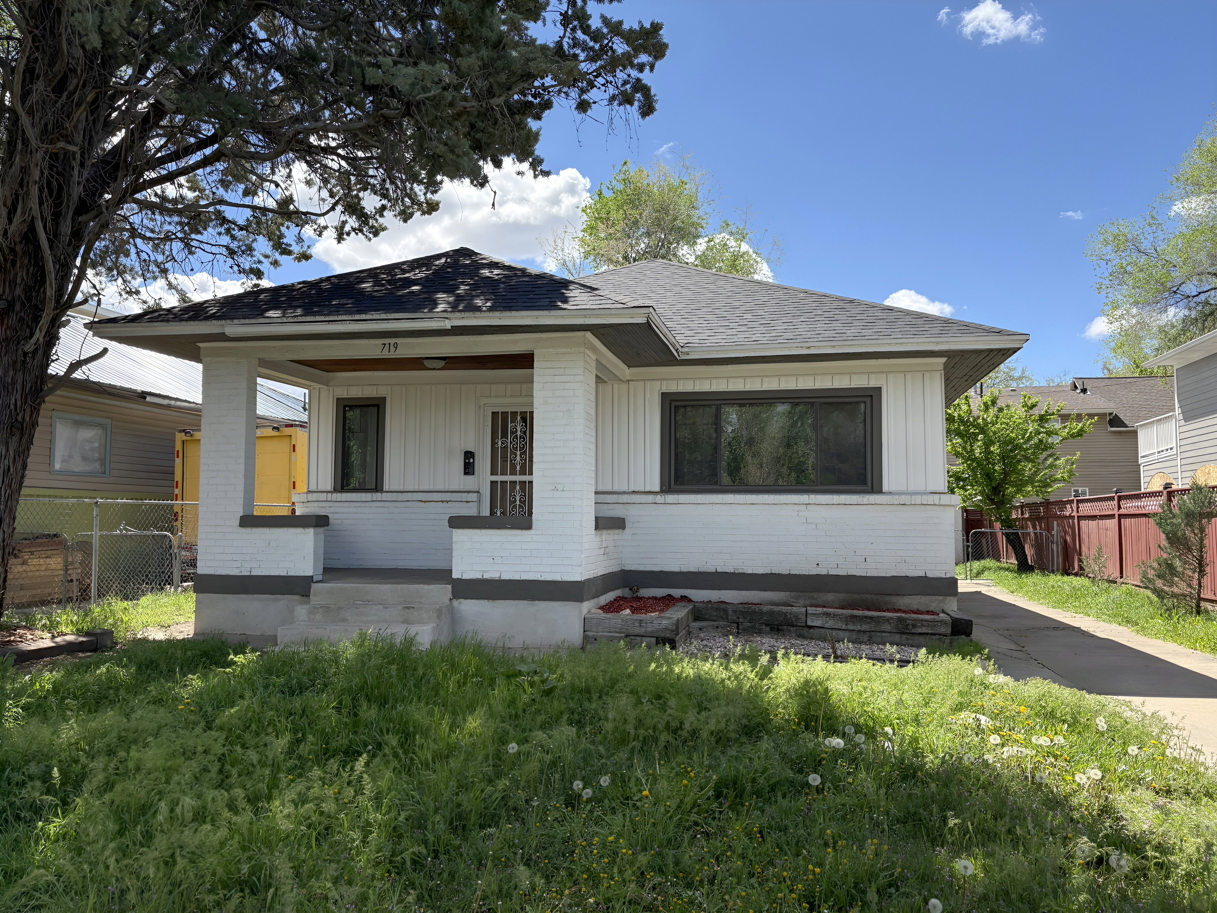 Single-story residence featuring a covered front porch with white brick columns and trim