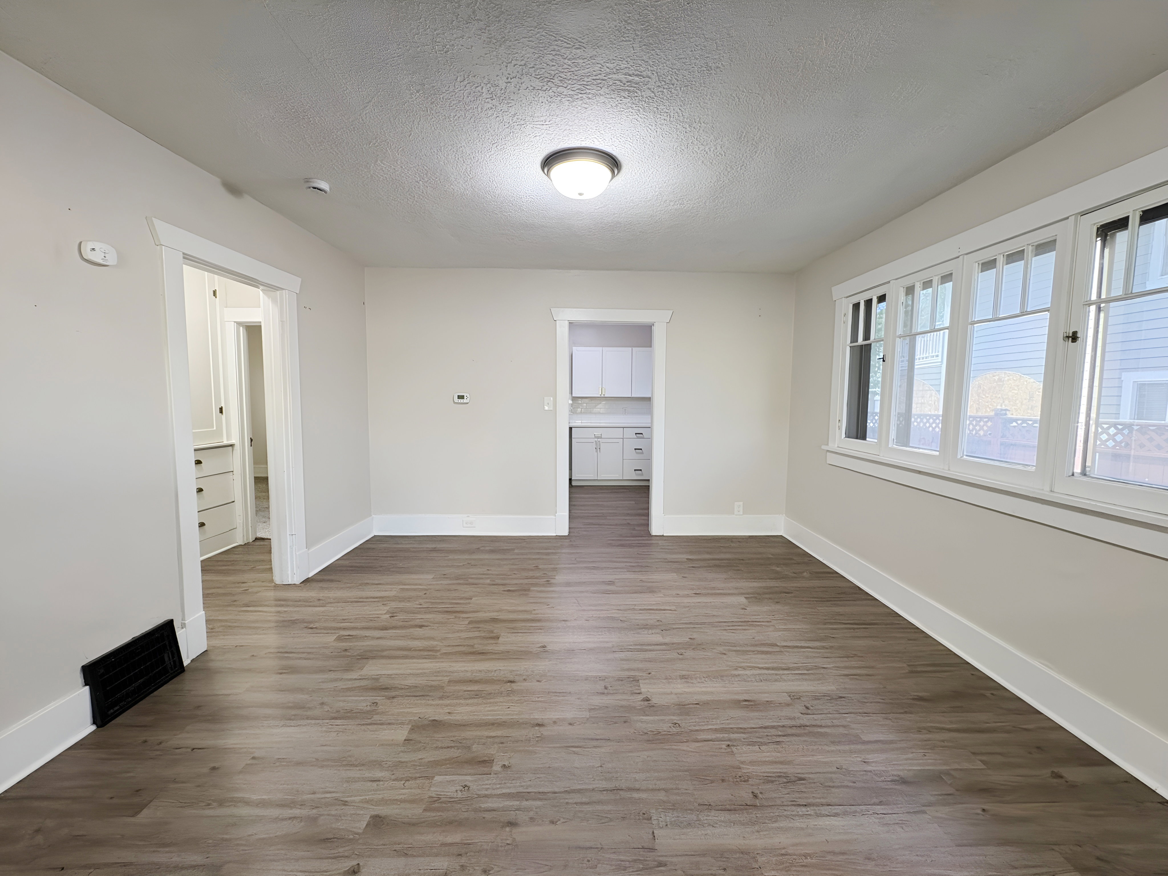 Living area featuring wood-finish flooring, white baseboards, and neutral wall tones