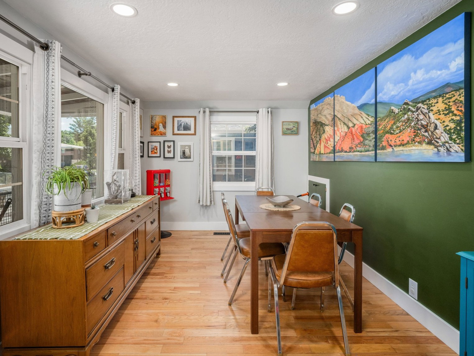 Dining area featuring wood-finish flooring, recessed lighting, and a prominent green accent wall