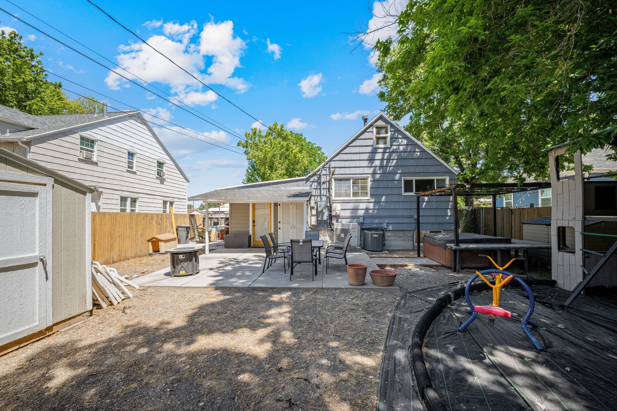 Backyard featuring a concrete patio, gravel hardscaping, and a wooden fence