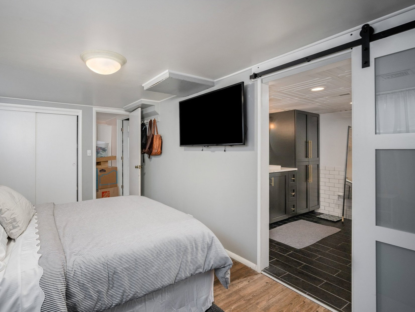 Bedroom featuring wood-finish flooring, a wood headboard, and a double sliding closet door