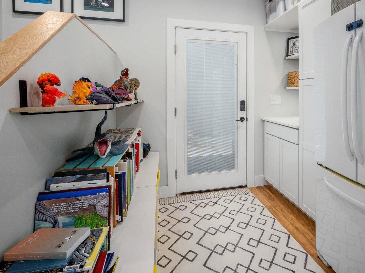 Entryway featuring a white paneled door with frosted glass, wood-finish flooring, built-in shelving, white cabinetry, and recessed lighting
