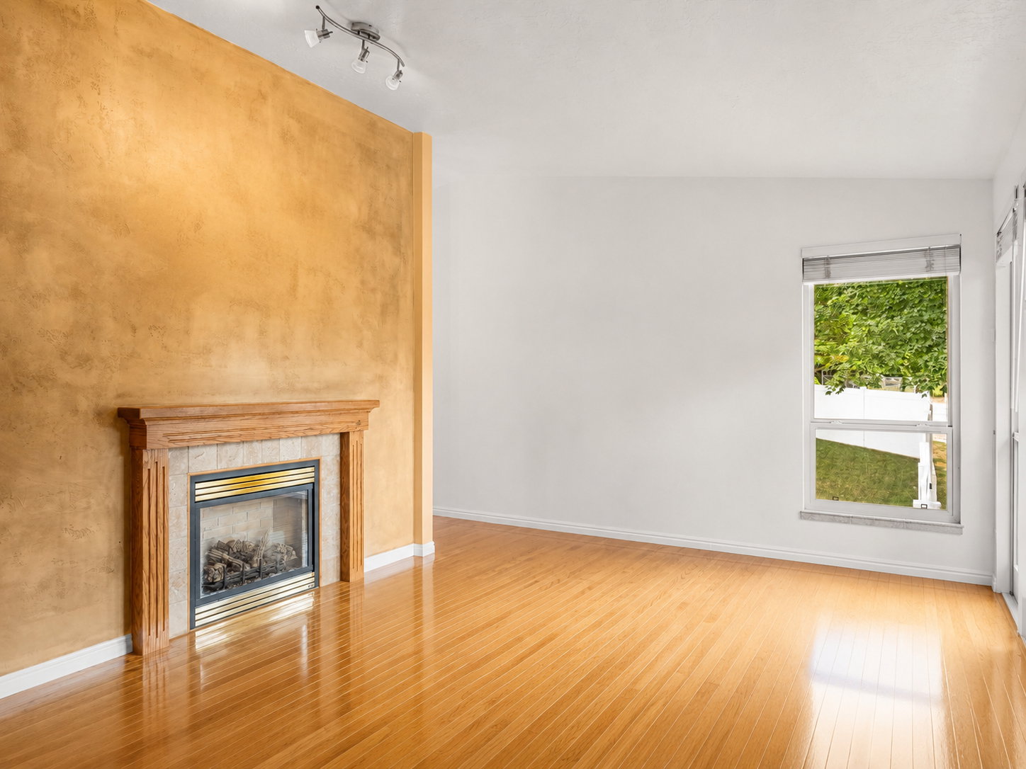 Living space featuring a wood floor and gas a fireplace with a wood mantle and tile surround