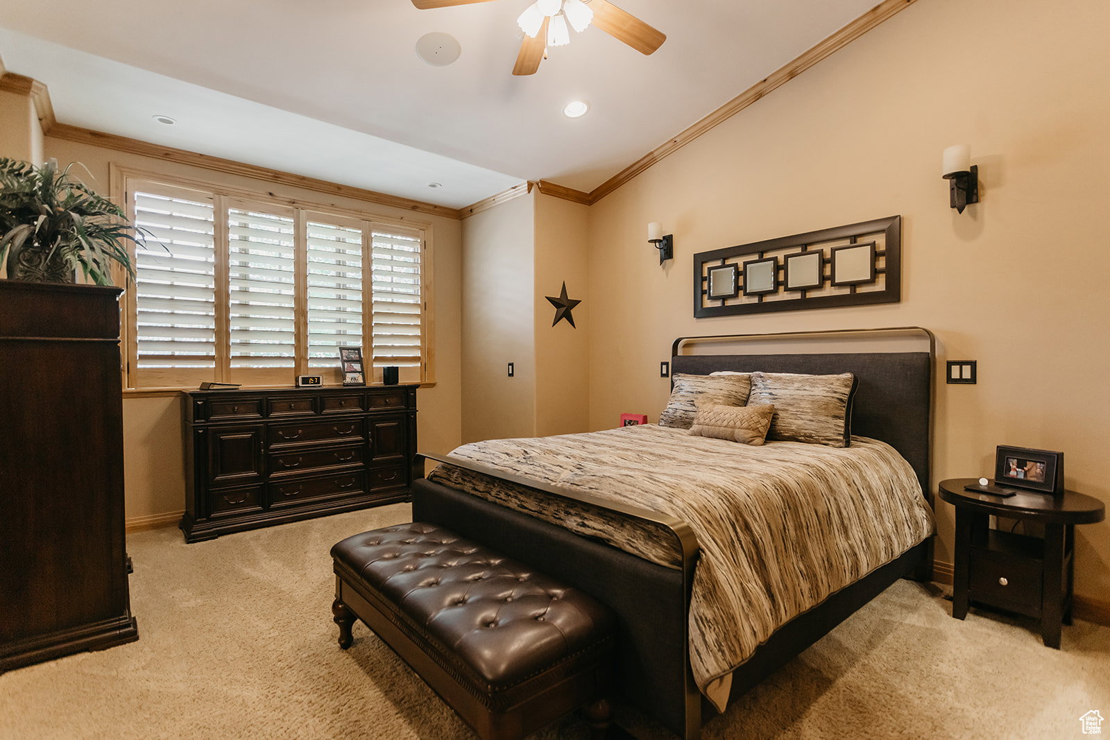 Spacious sleeping area featuring vaulted ceilings with wood-finish trim, plantation shutters, recessed lighting, and a ceiling fan