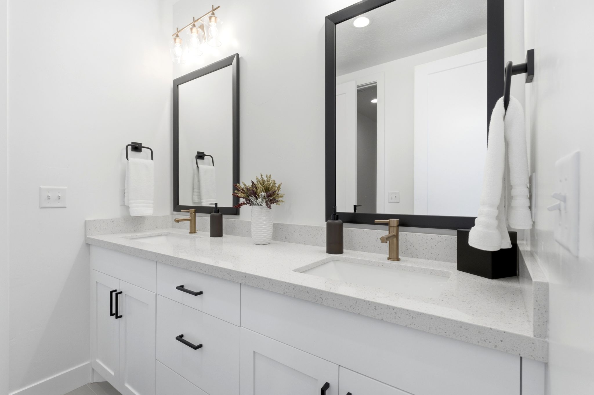 Dual vanity with white cabinetry and black hardware