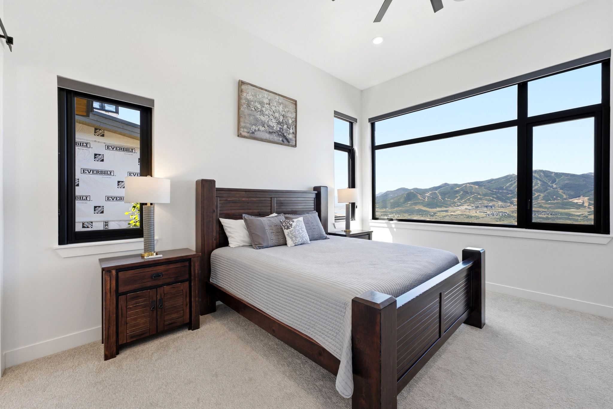 Spacious bedroom featuring expansive windows, neutral carpeting, recessed lighting, and a ceiling fan